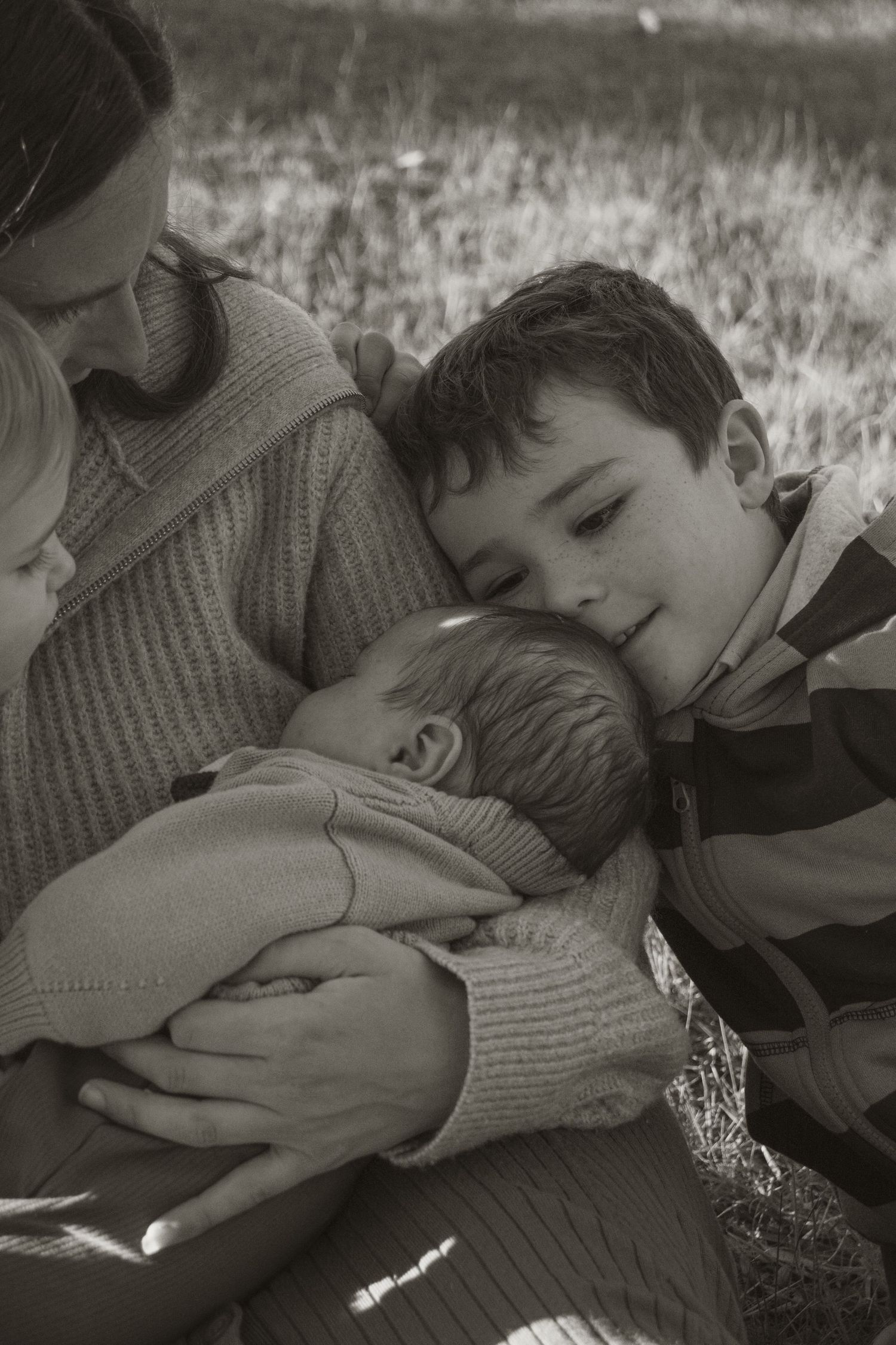 A family cuddling together at blue rock lake in the outdoors in central Gippsland. Taken for a motherhood/pet session.