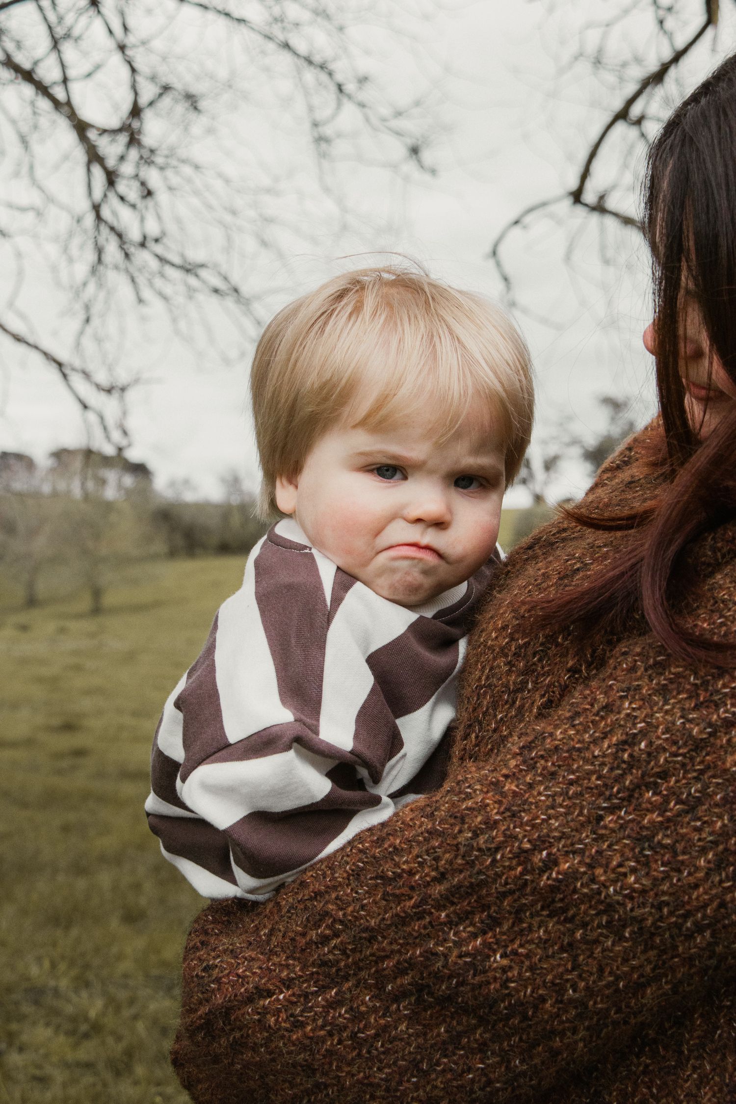 Toddler pulling a face in mums arms,  in the afternoon at lifestyle family photography session in Trafalgar, West Gippsland.