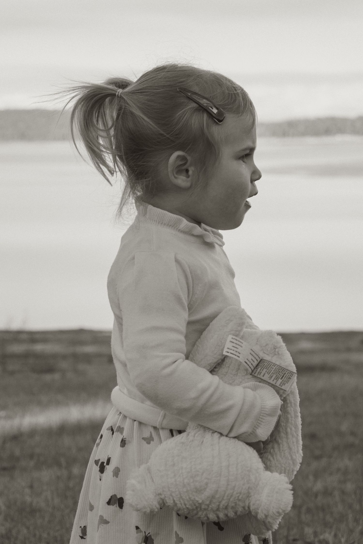 A child holding her teddy bear at blue rock lake with family in the outdoors in central Gippsland. Taken for a motherhood/pet session.