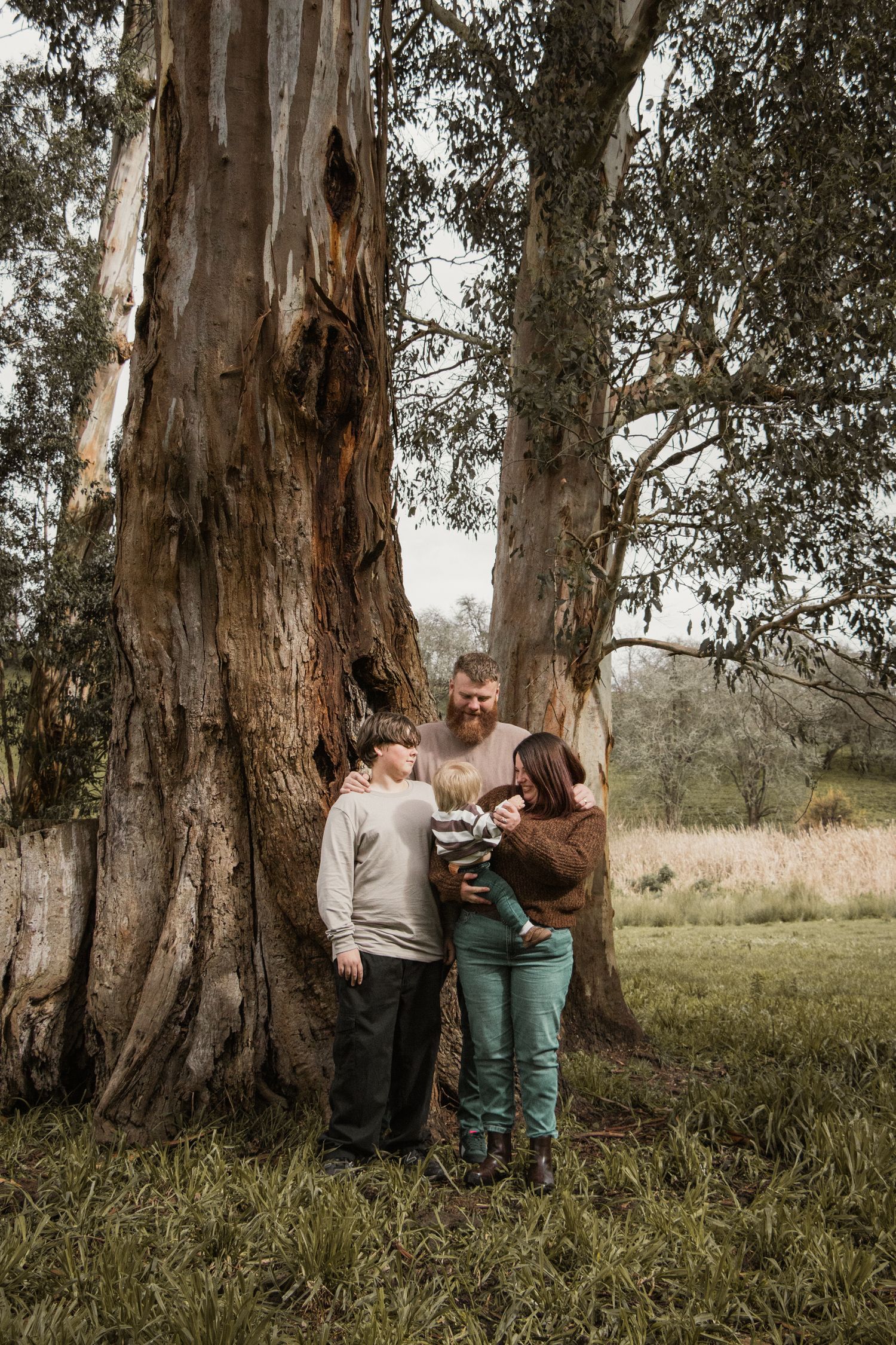 Family looking at each other smiling and laughing,  in the afternoon at lifestyle family photography session in Trafalgar, West Gippsland.