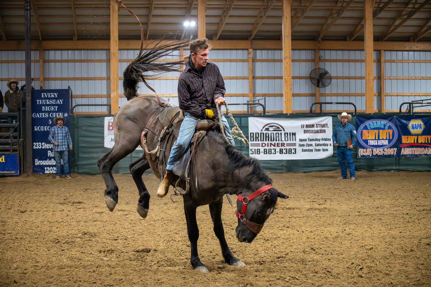 Dynamic sequence of rodeo riders performing in an indoor arena with spectators.