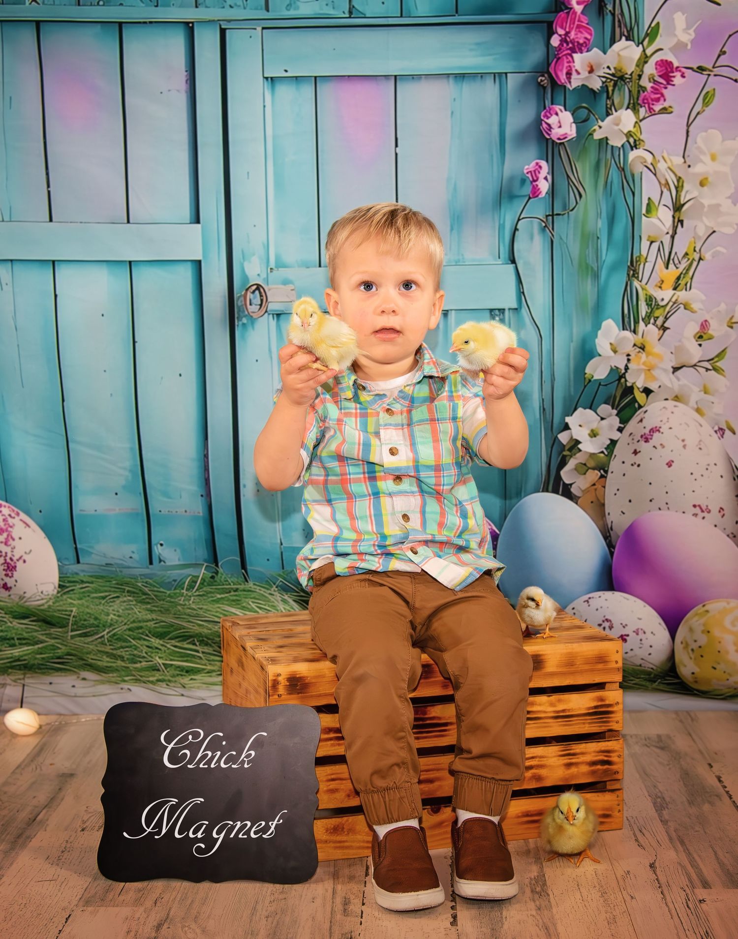 Child sitting on wooden crates with Easter decorations and props.
