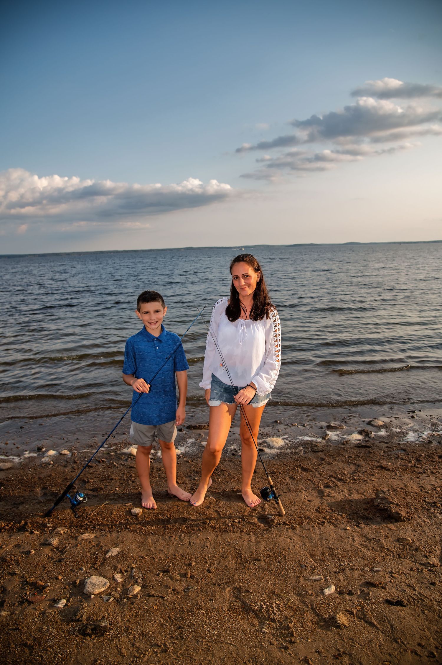 Family enjoying a sunset moment while exploring a rocky beach shoreline.