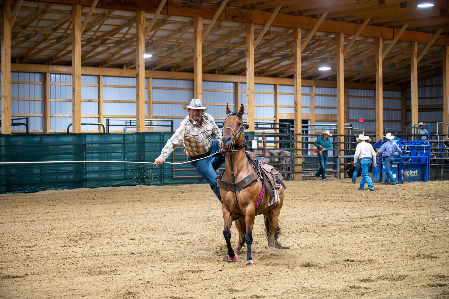 Wide angle view of indoor equestrian arena during training session.