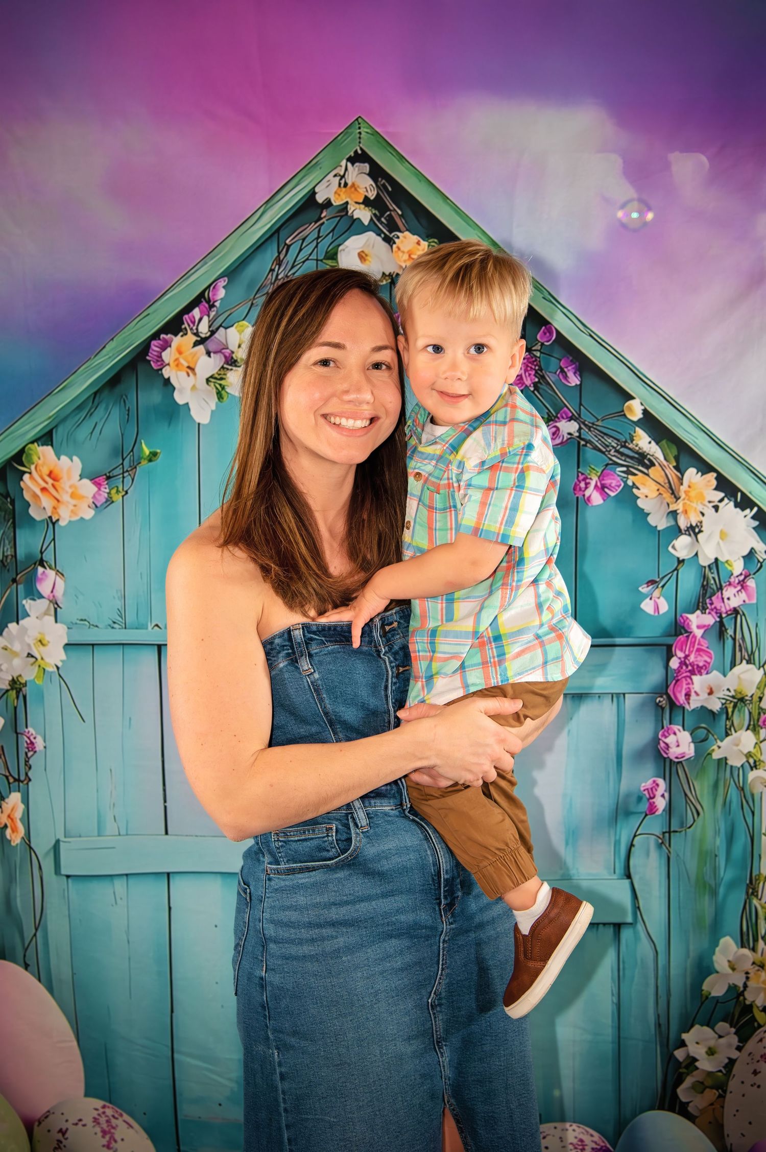 Portrait session against turquoise wooden backdrop with floral decorations.