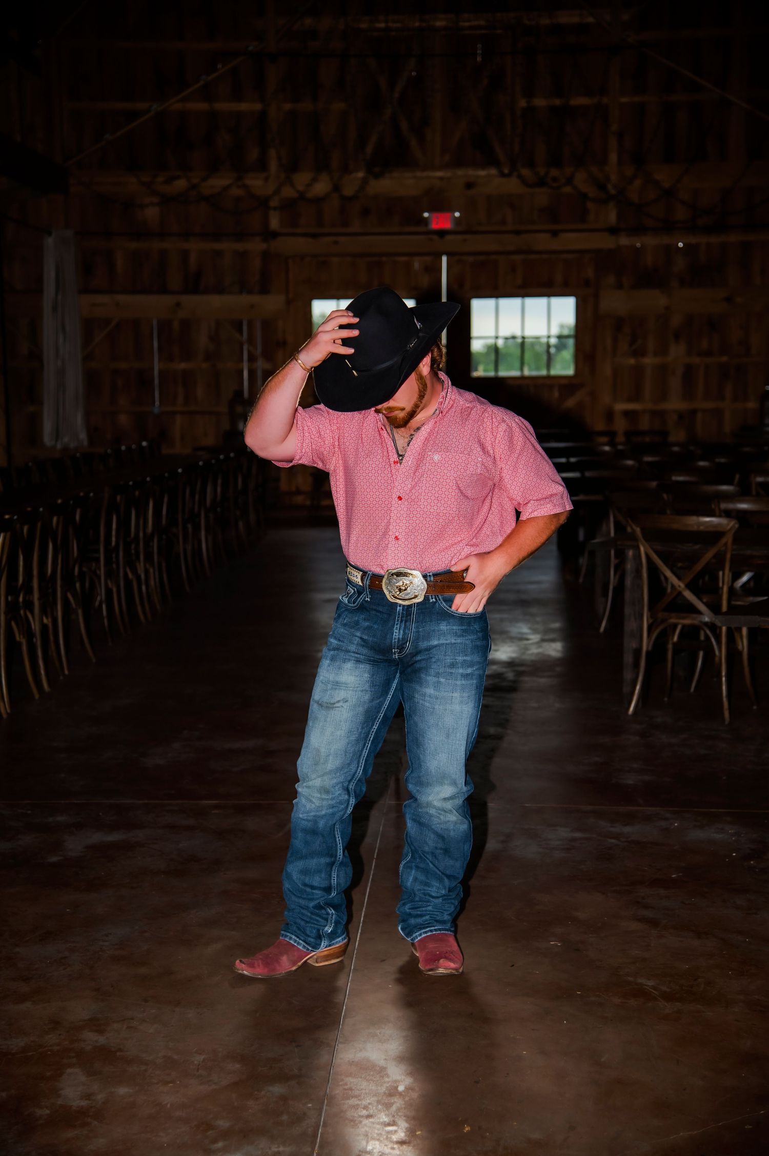 Pink-shirted figure dancing in a dimly lit rustic barn interior.