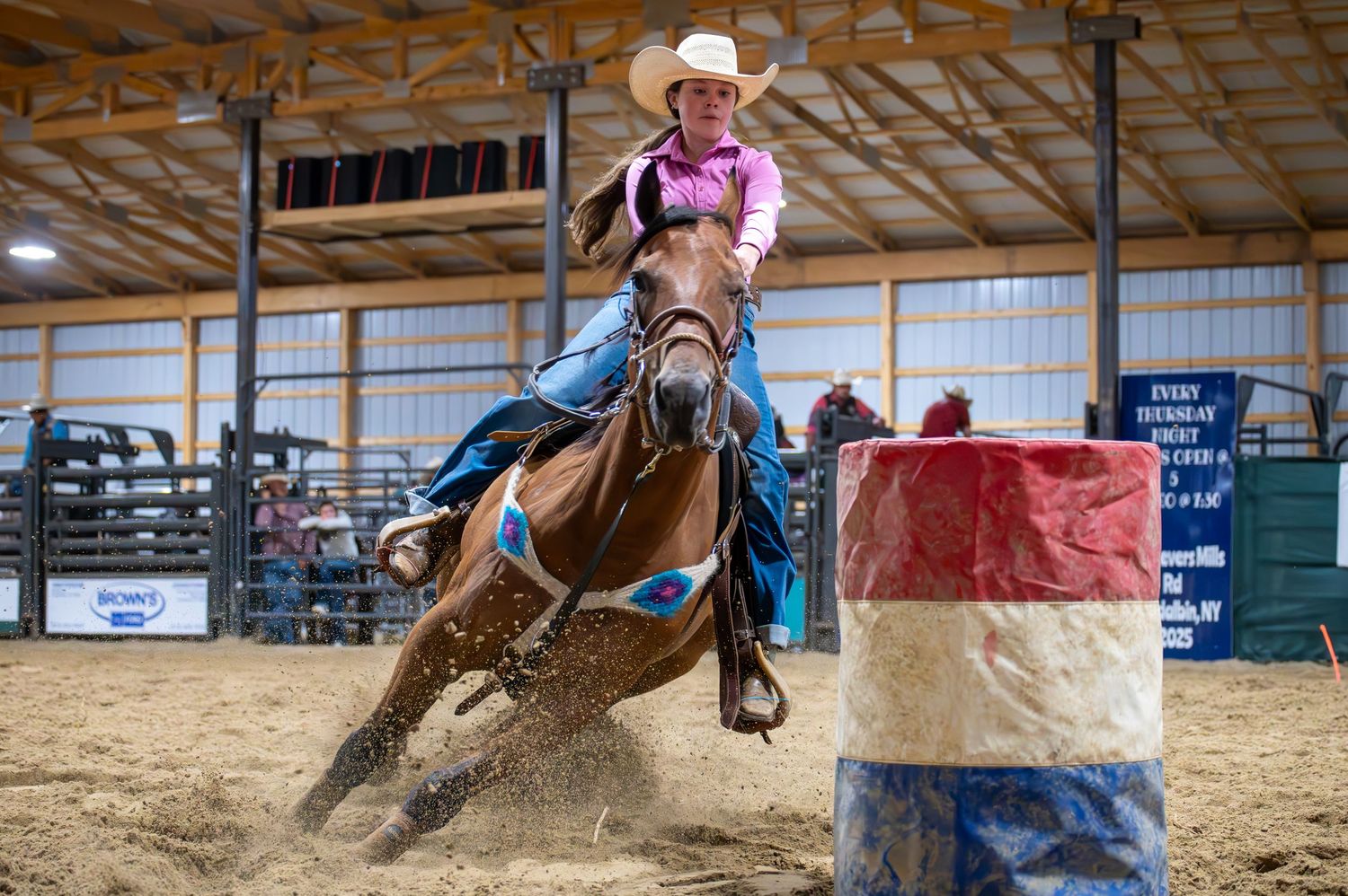 Horse and rider performing quick turns during indoor rodeo competition.