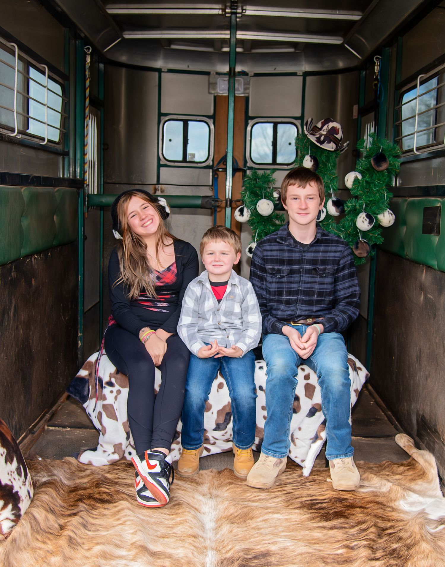 Family photo with multiple Basset Hound puppies in rustic barn setting.