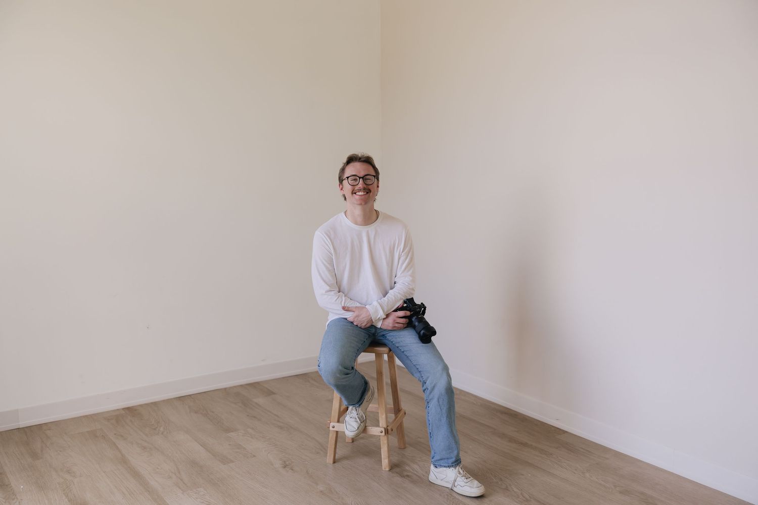 A portrait of Evan Patzwald holding a camera for Evan Patzwald Media.