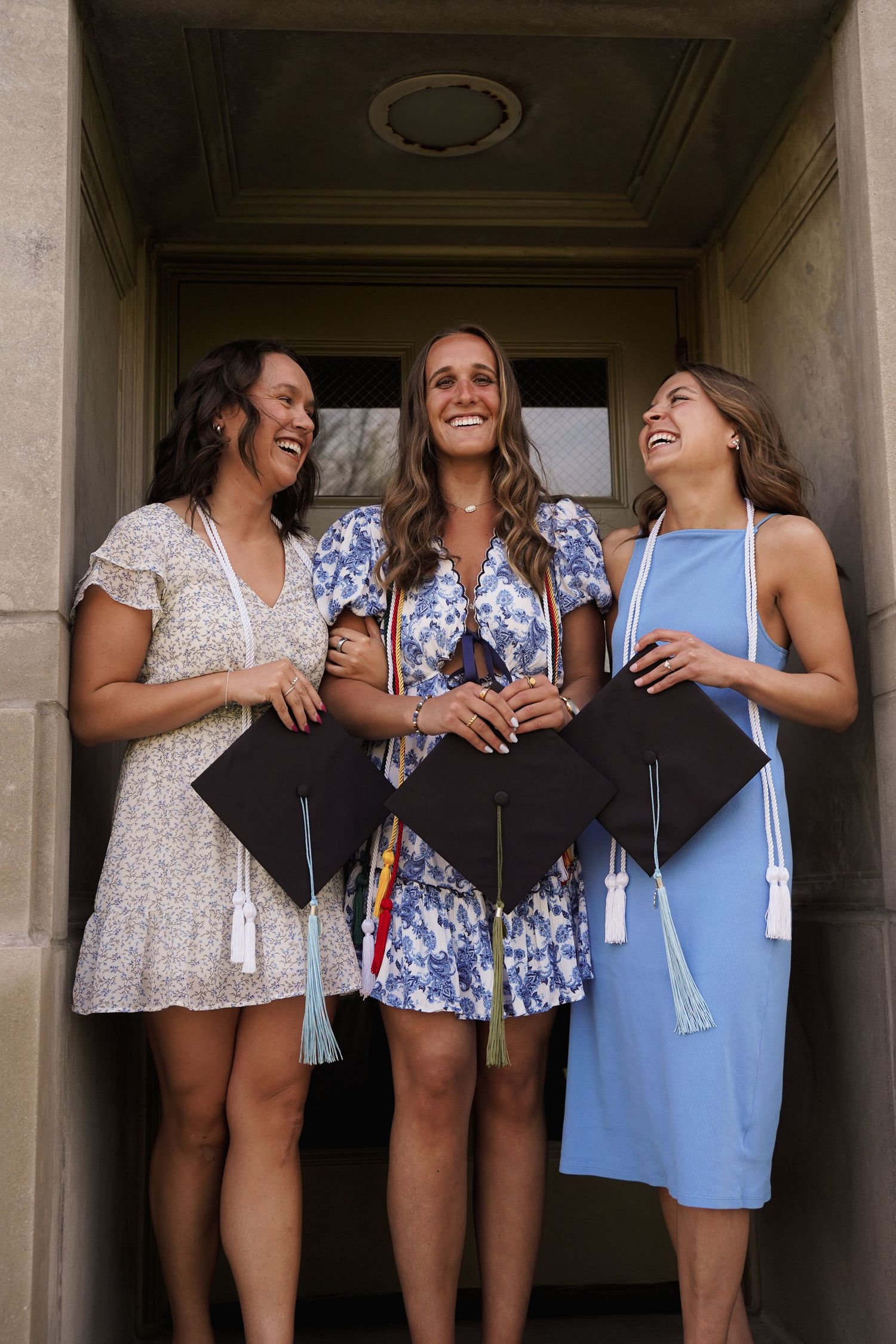 A portrait of three girls posing in a cap & gown by Evan Patzwald Media.