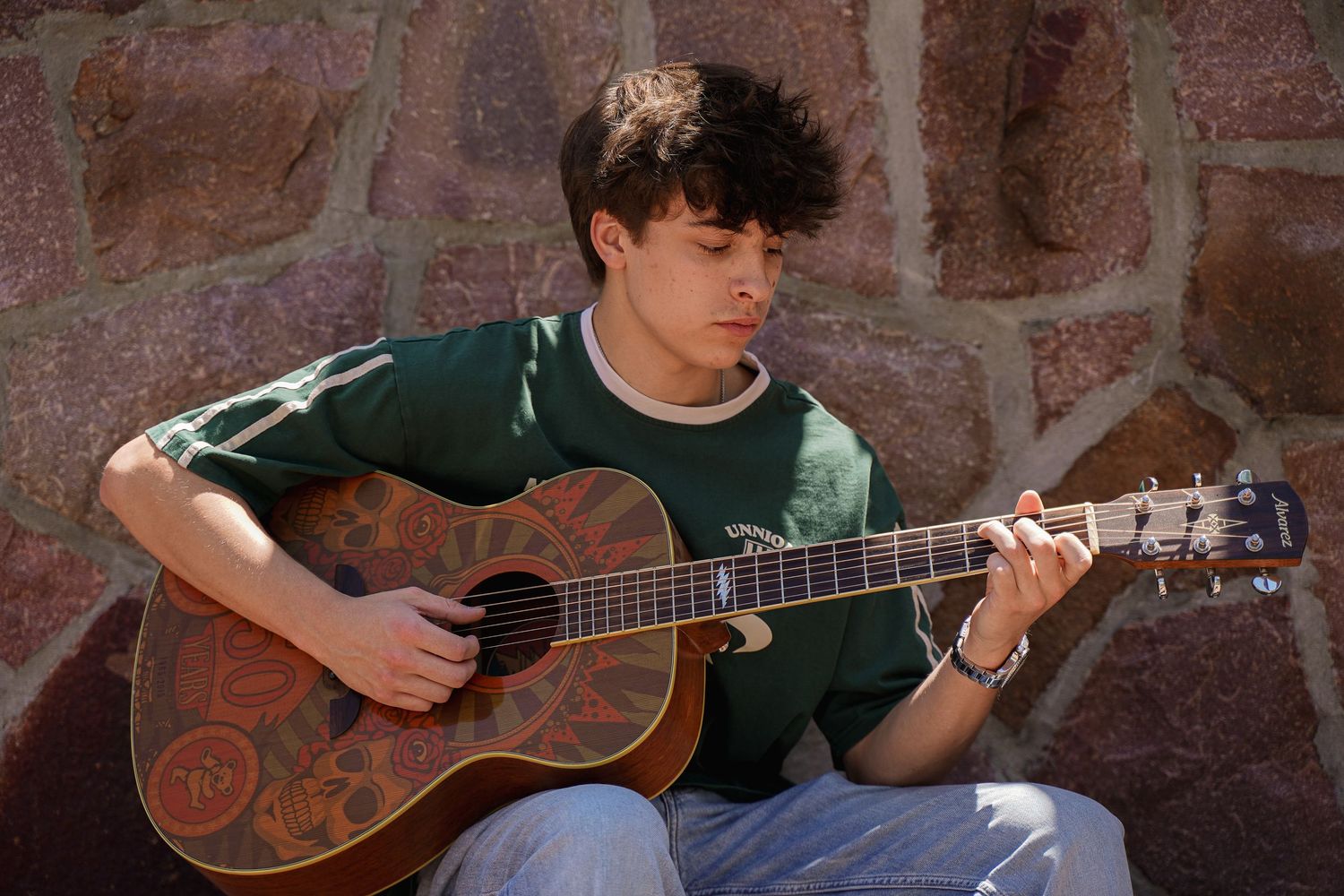 A portrait of a boy holding a guitar by Evan Patzwald Media.