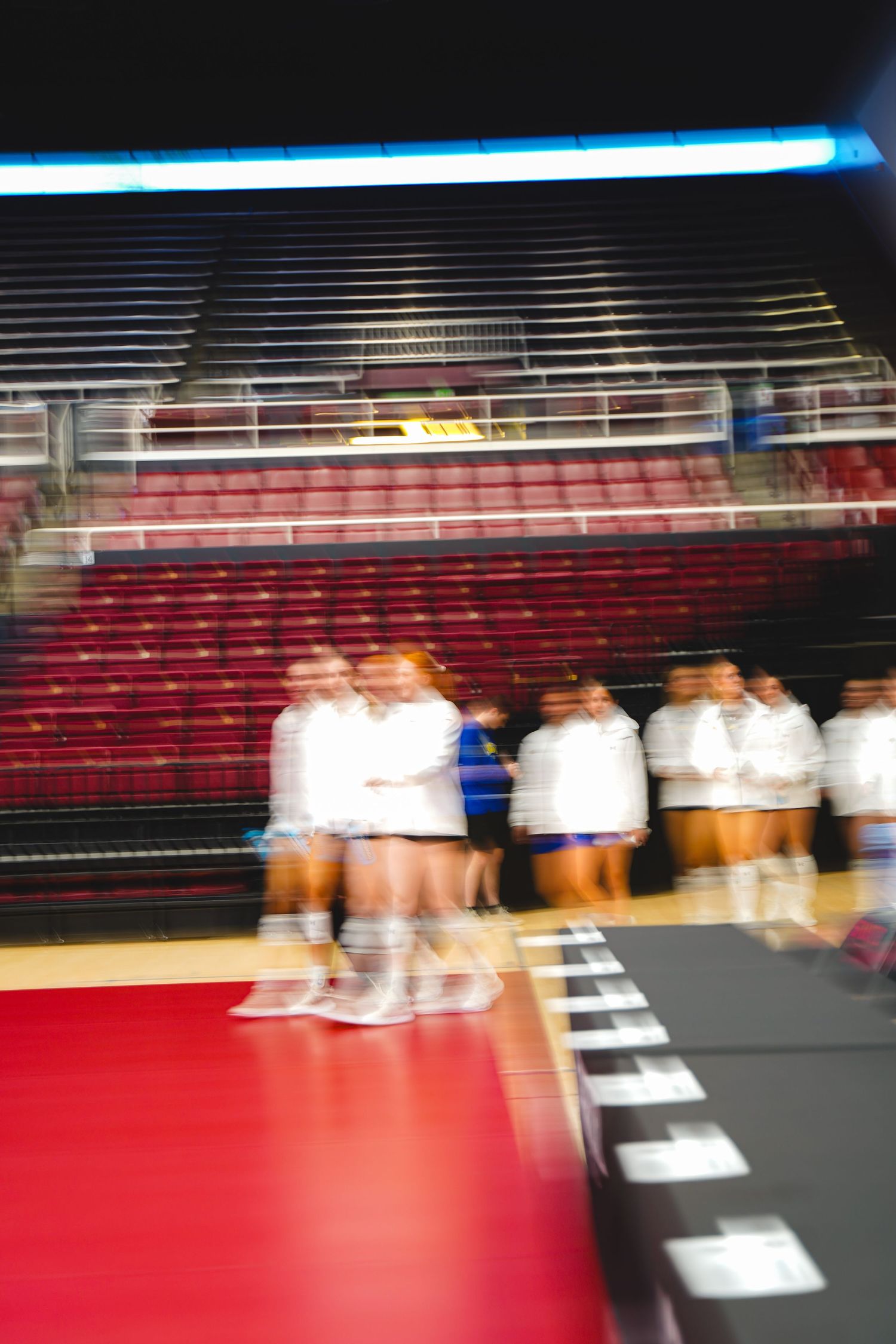 A slow shutter shot of a volleyball team walking onto the court by Evan Patzwald Media.