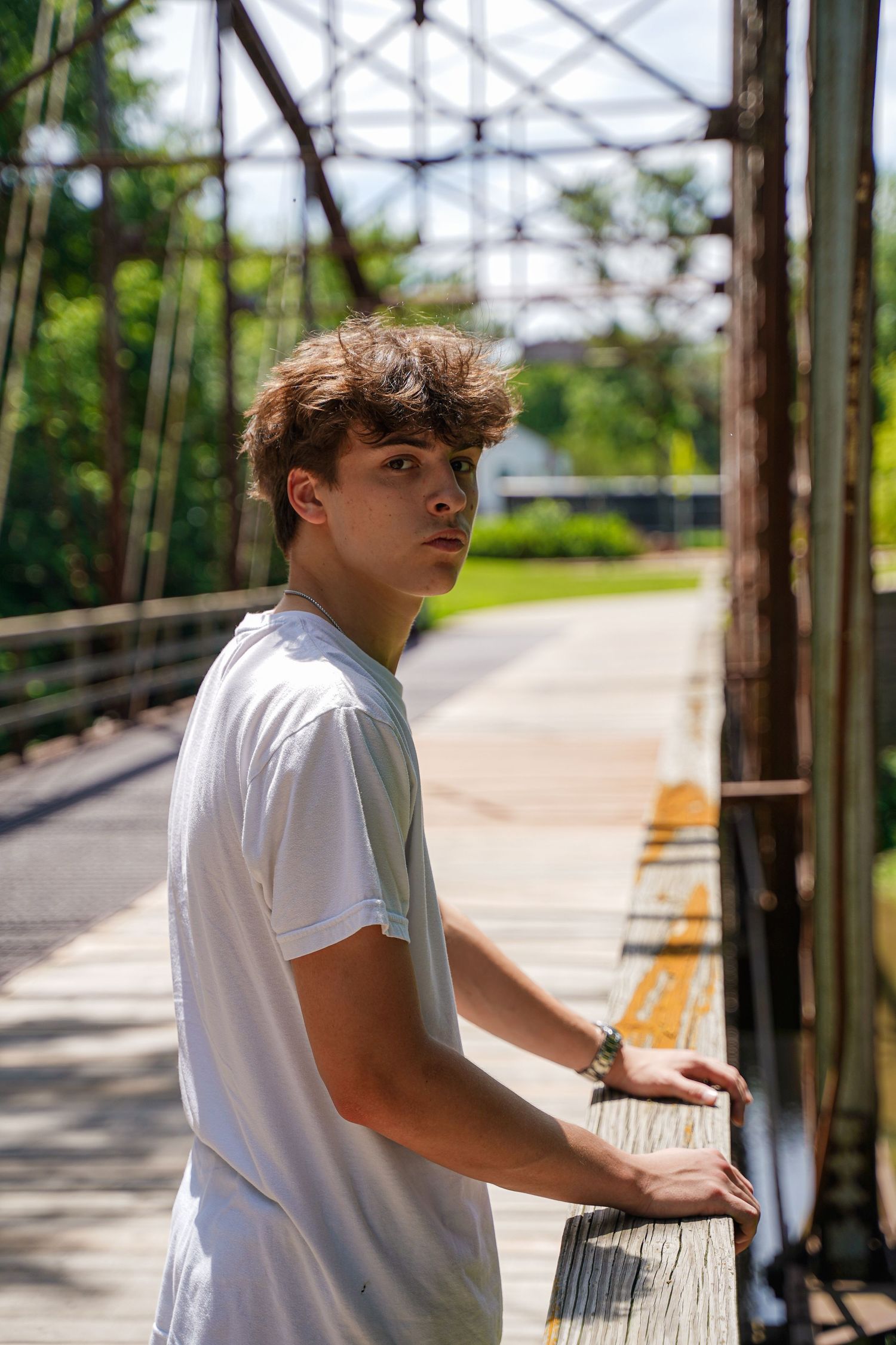 A portrait of a boy posing on a bridge by Evan Patzwald Media.