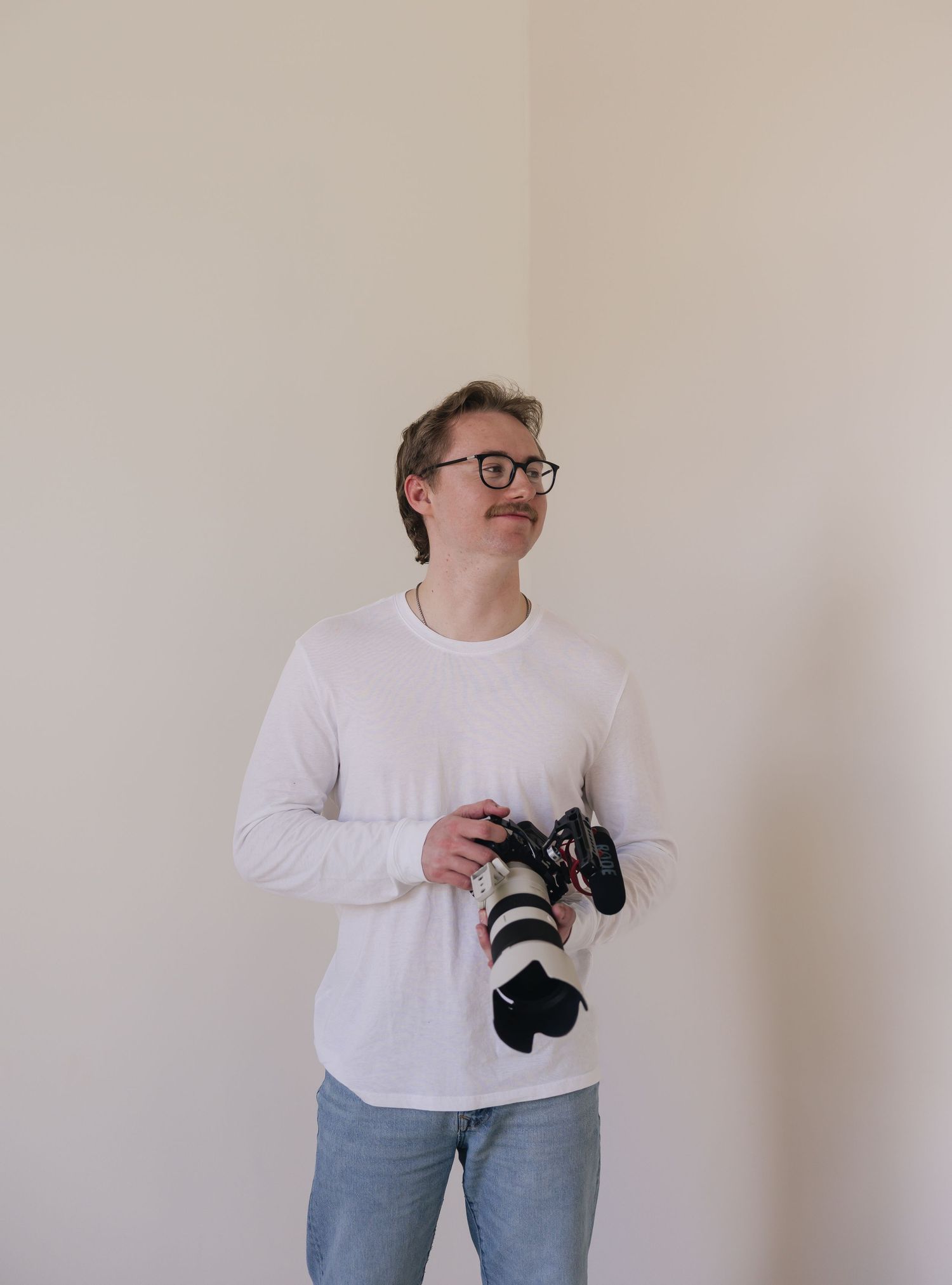 A photo of Evan Patzwald holding a camera for Evan Patzwald Media.