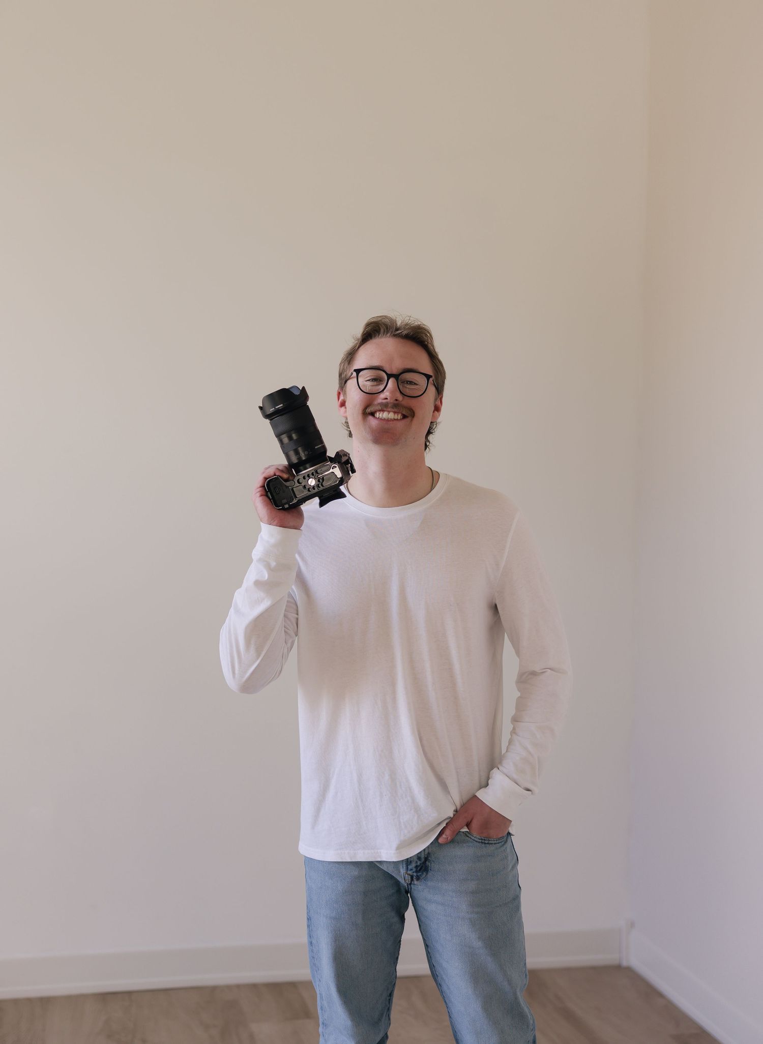 A portrait of Evan Patzwald holding a camera for Evan Patzwald Media.