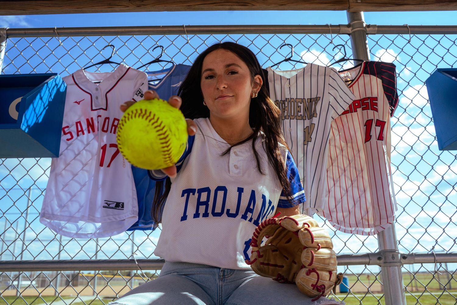 A portrait of a girl holding up a softball by Evan Patzwald Media.