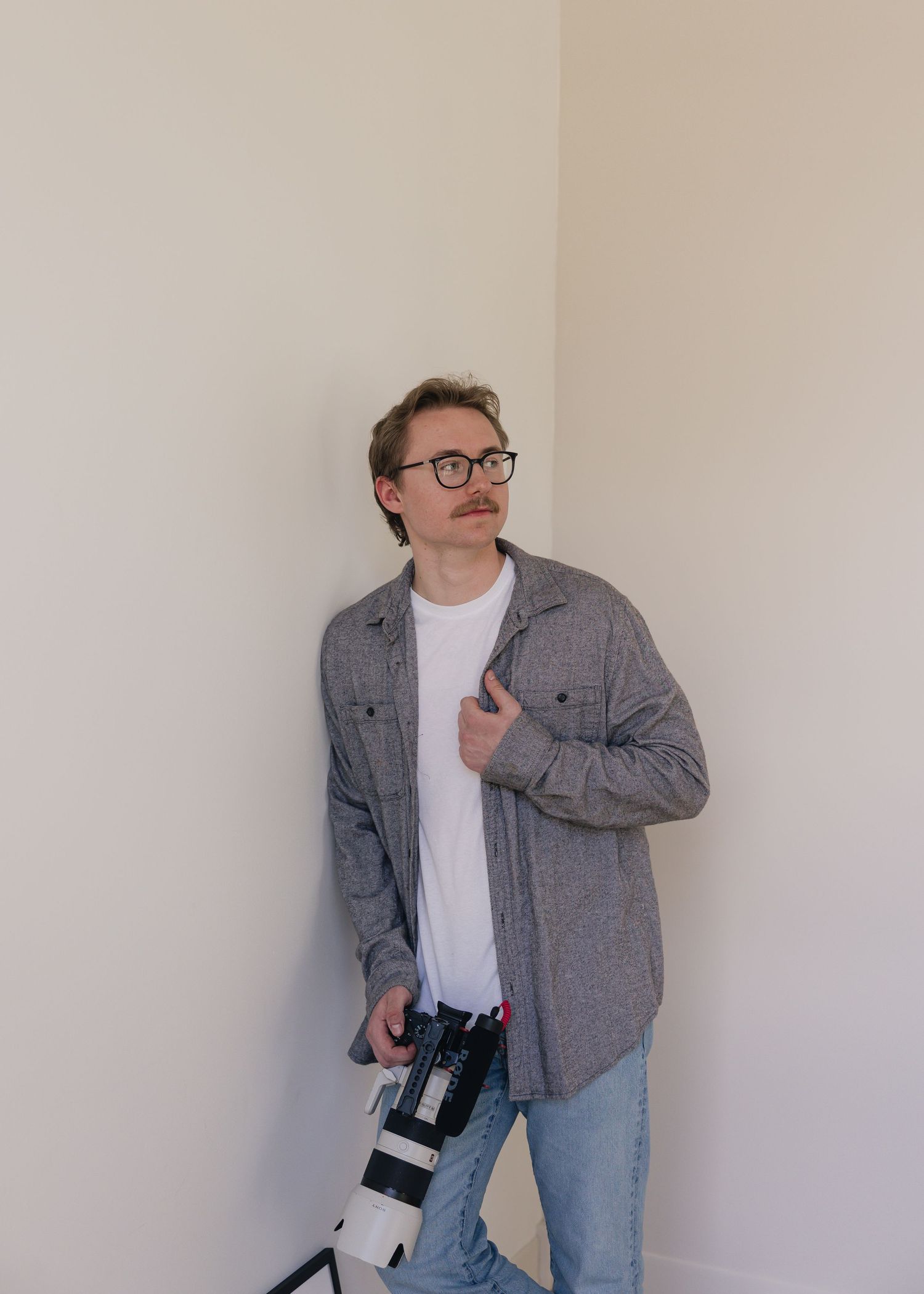 A portrait of Evan Patzwald holding a camera for Evan Patzwald Media.