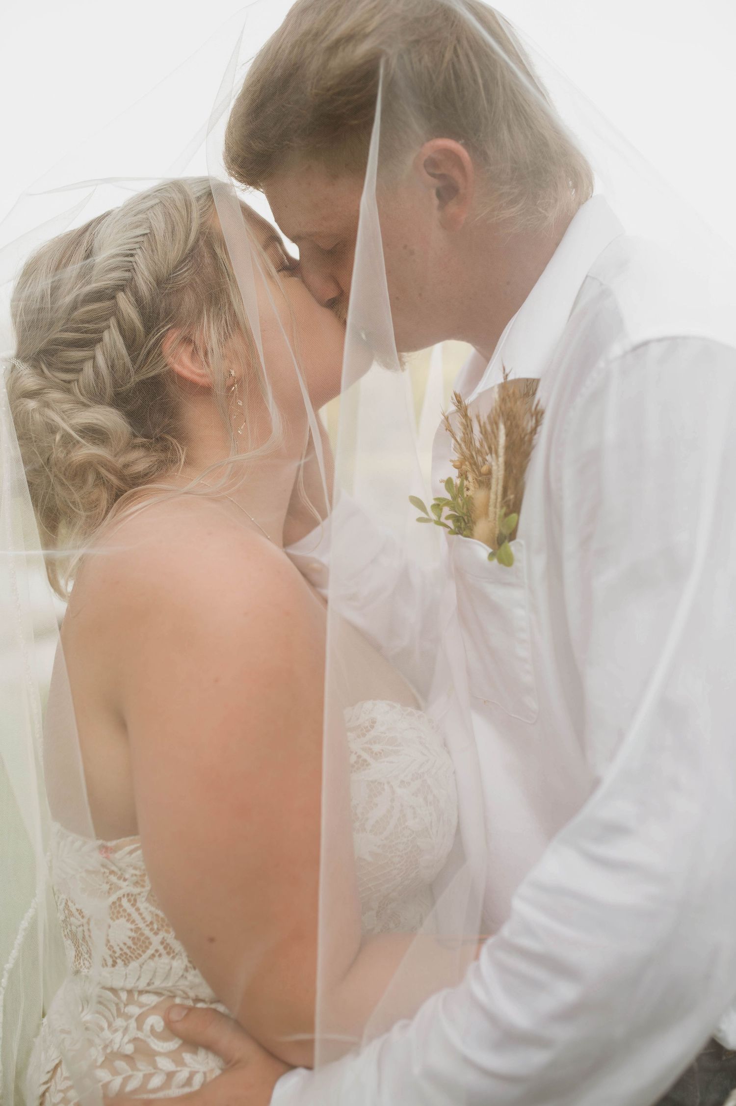 A bride and groom kissing one another.
