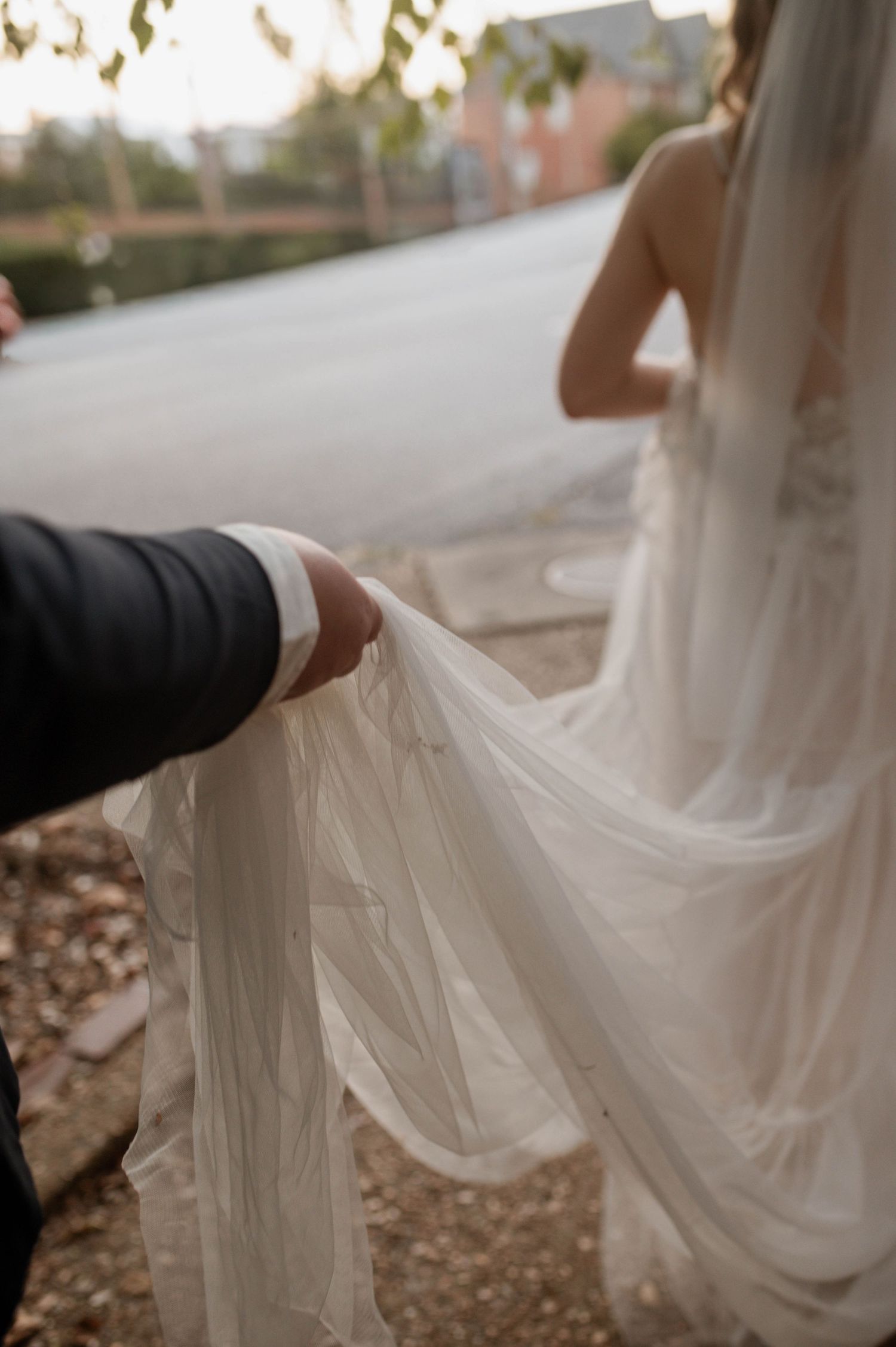 One partner holding the other's wedding dress.