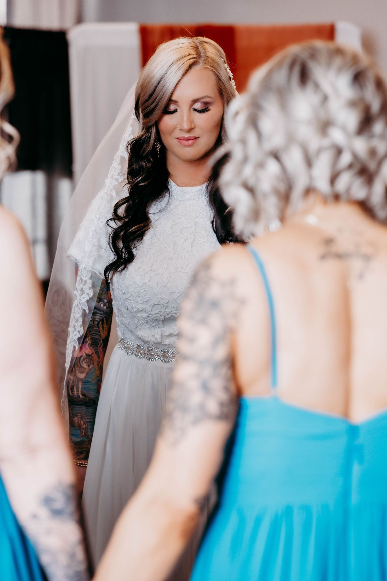 A bride closing her eyes while her bridesmaids pray for her.