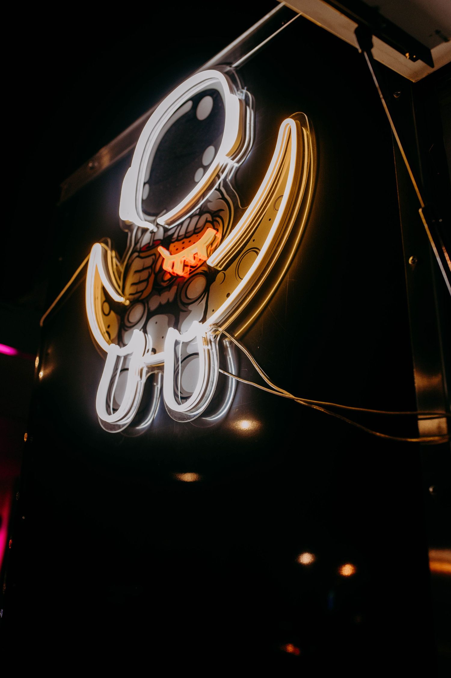 A neon sign featuring an astronaut sitting on a crescent moon.