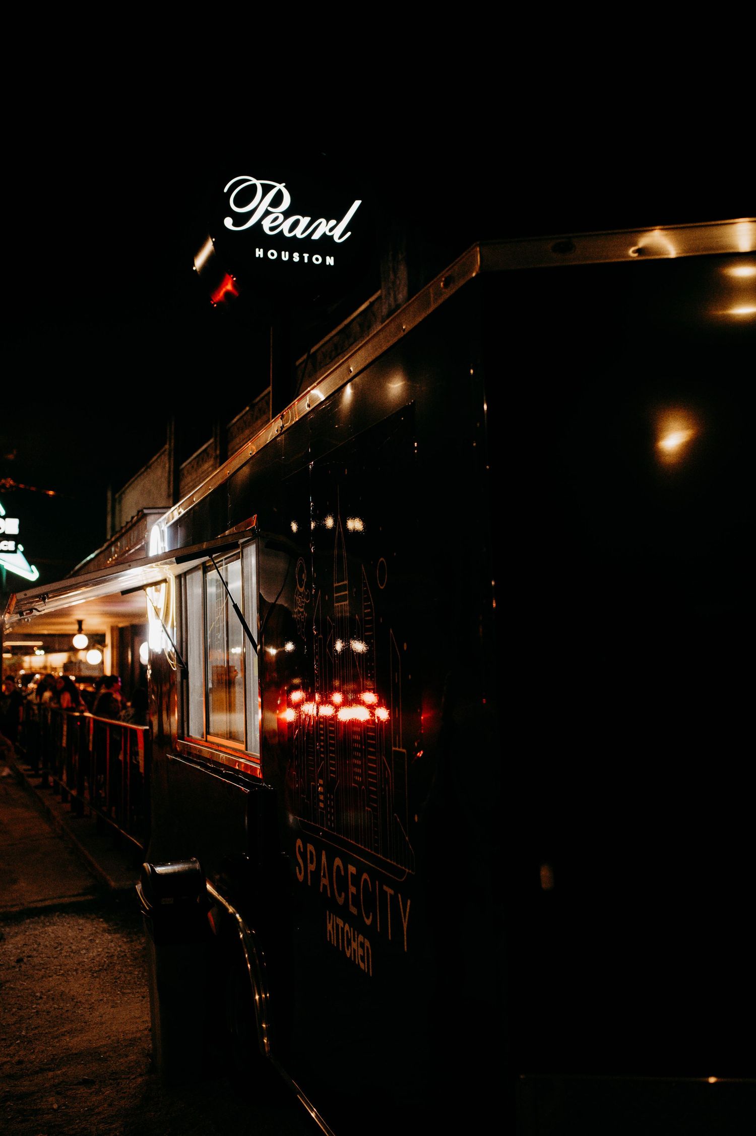 A food truck in front of a night club in Houston.