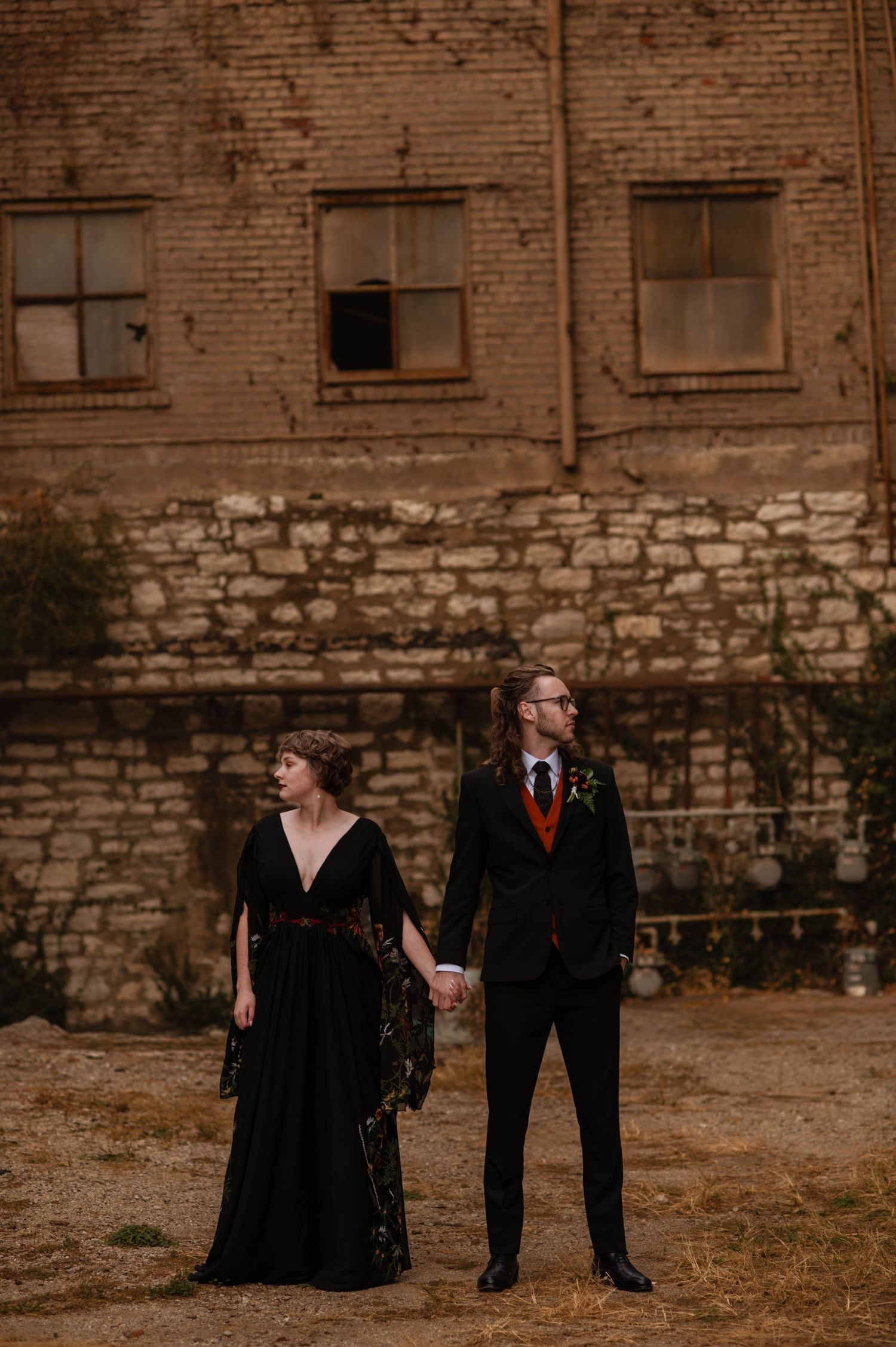 bride and groom holding hands and looking opposite directions