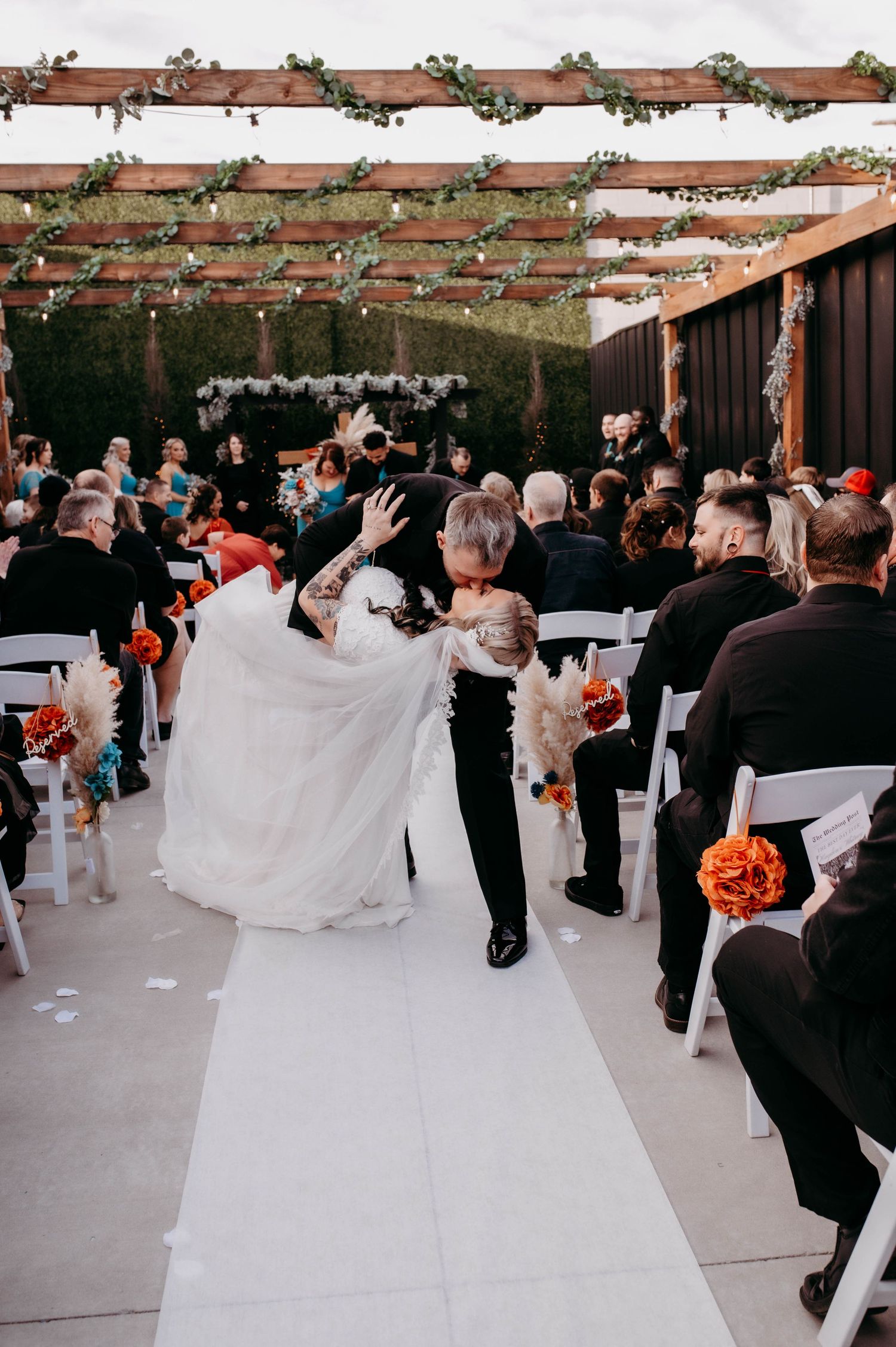 A groom dipping his bride and kissing her