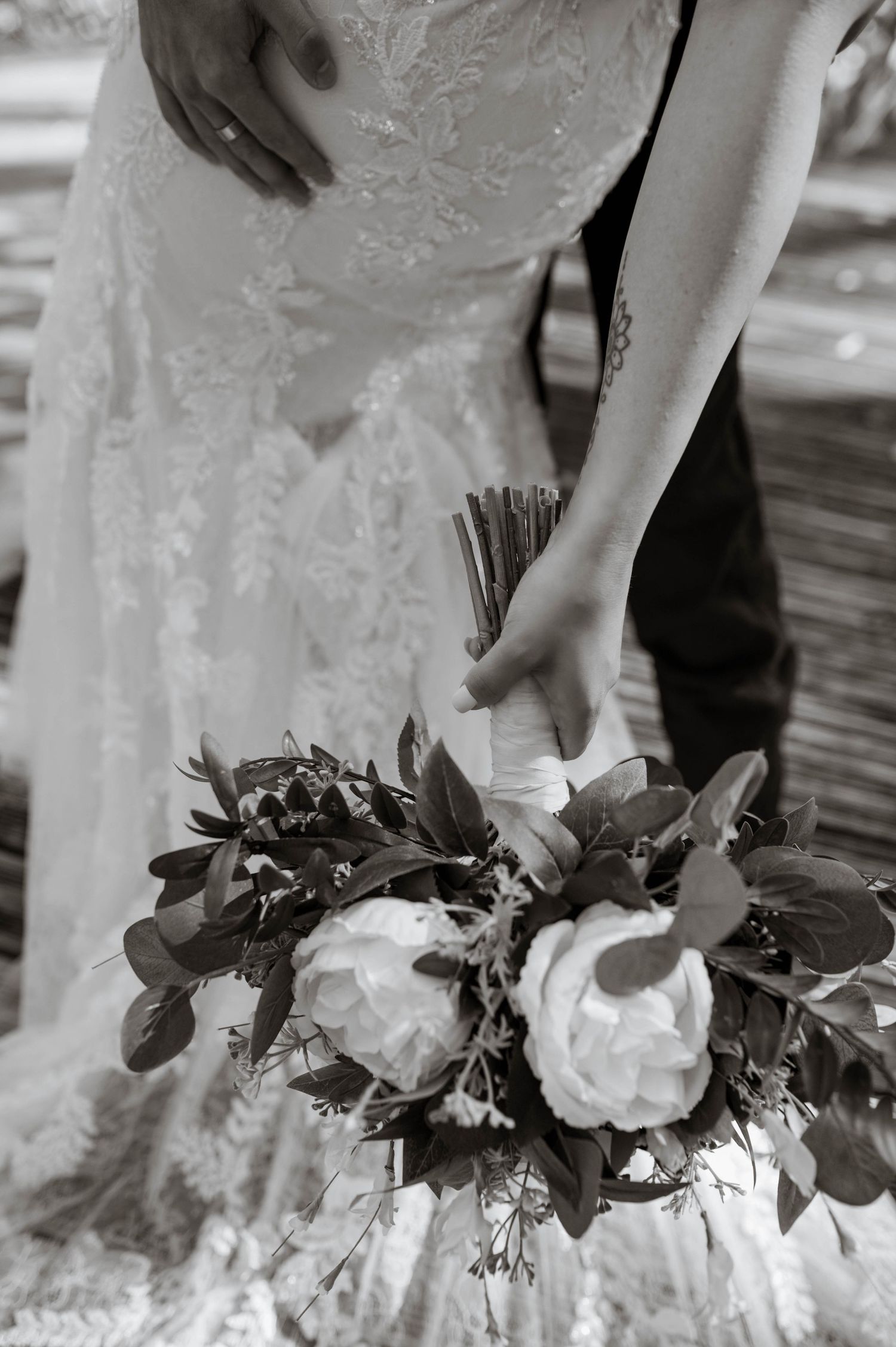 Flowers and wedding dress with a hand on her hip