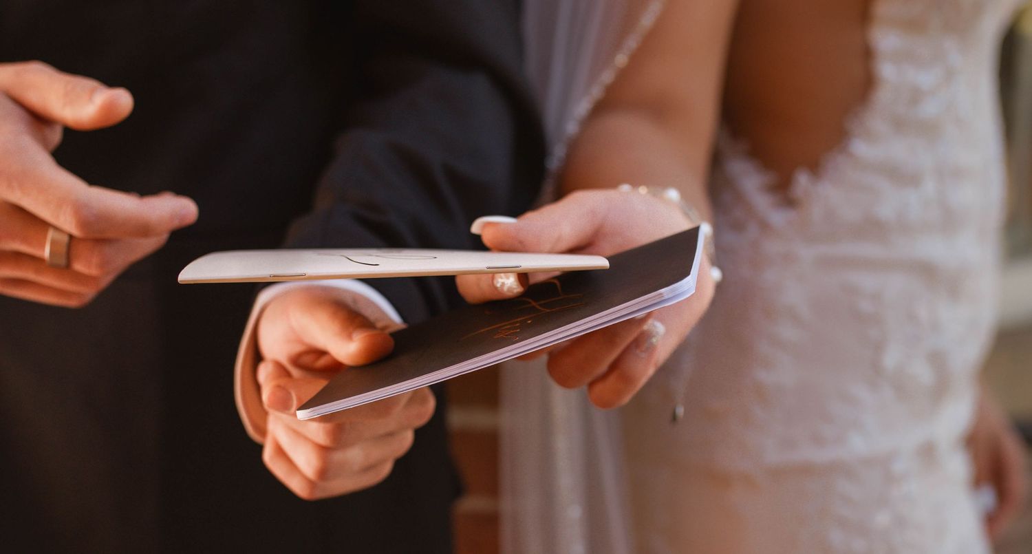 bride and groom exchanging vow books