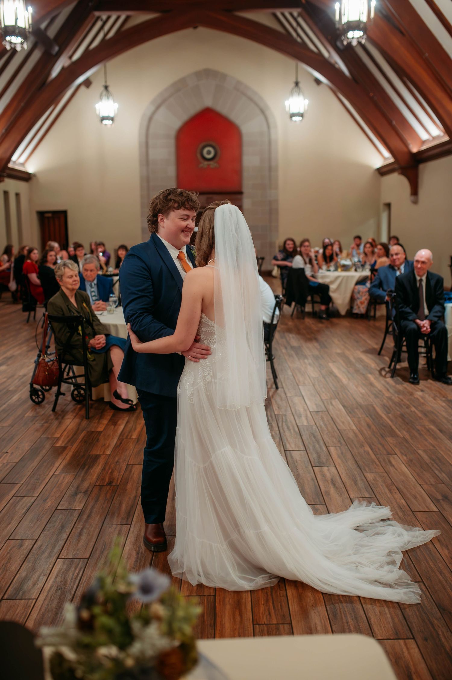 Two married people dancing in front of their wedding guests.