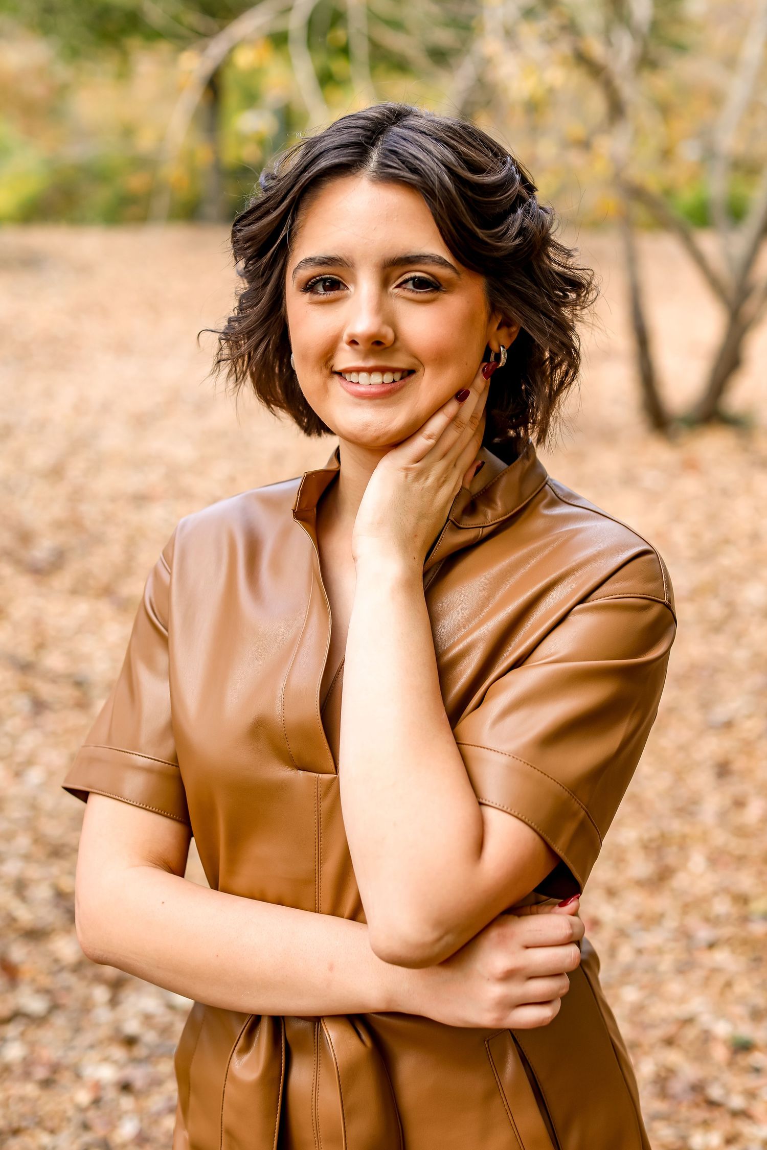 Portrait in brown dress with autumn foliage background.