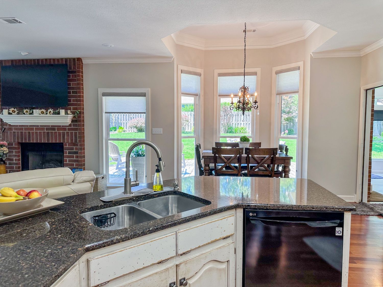 Spacious kitchen with granite countertops, dark wood cabinets, and large windows.