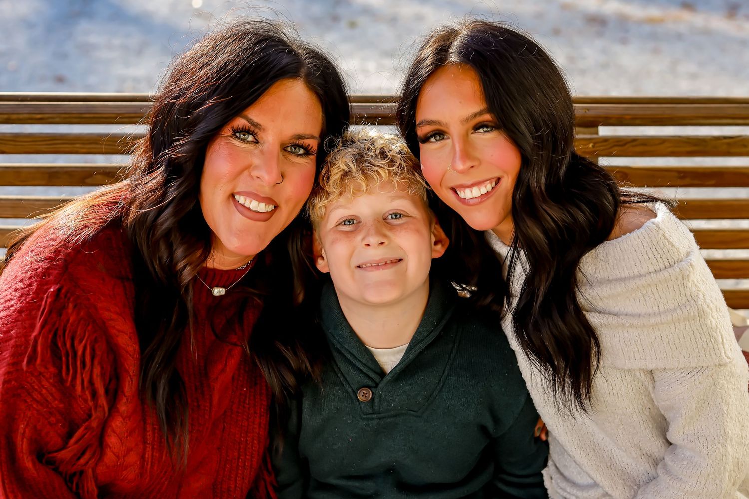 Family portrait session outdoors with casual poses and warm smiles.