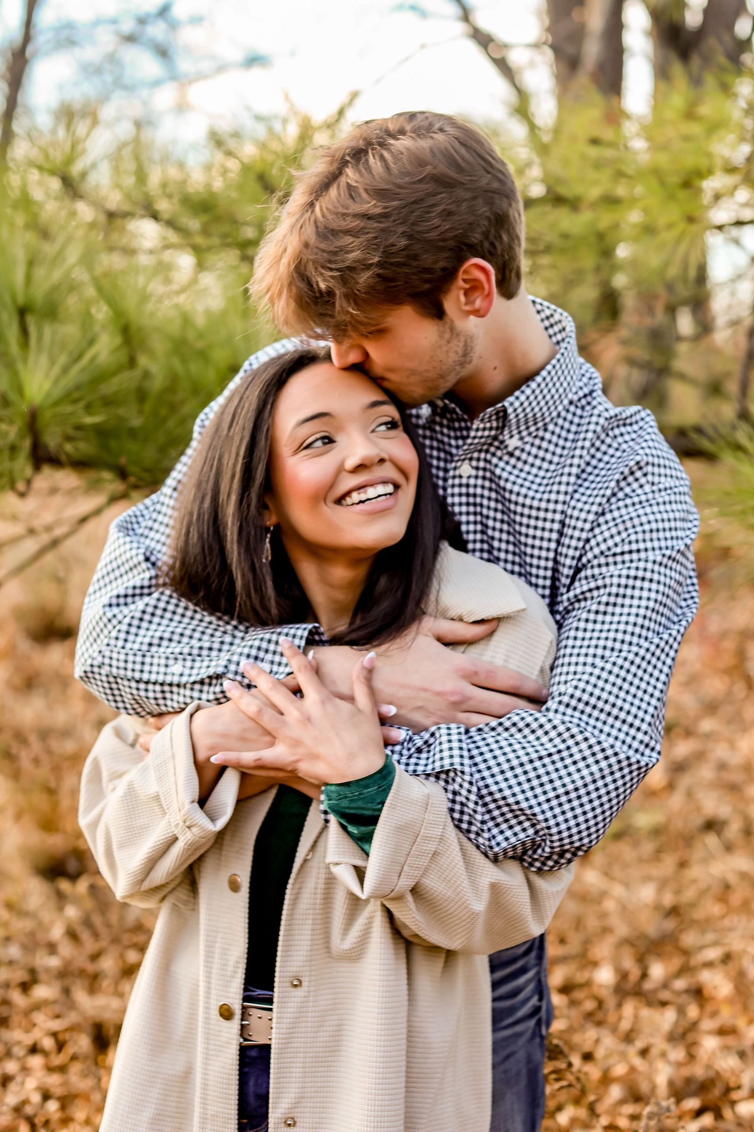 Romantic couple embracing outdoors among fall foliage.