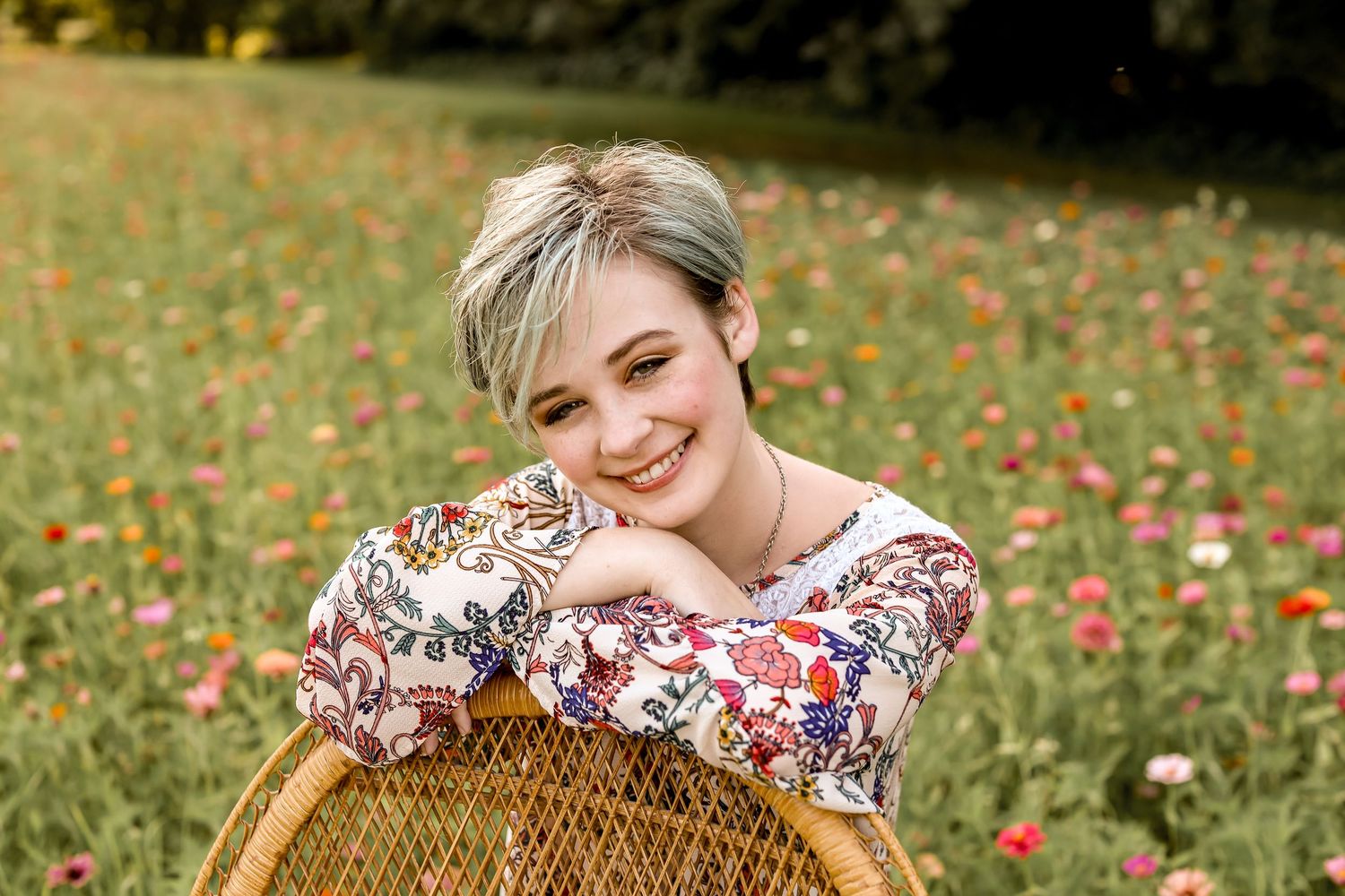 Autumn portrait session in field with wicker basket and floral dress.