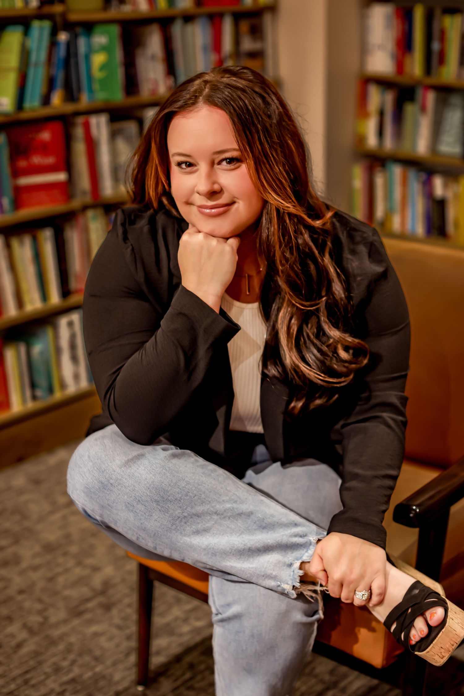 Casual portrait in library with bookshelves in background.