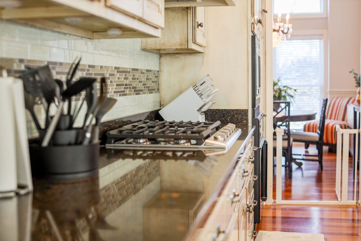 Bright kitchen interior with white cabinets and stainless steel appliances.