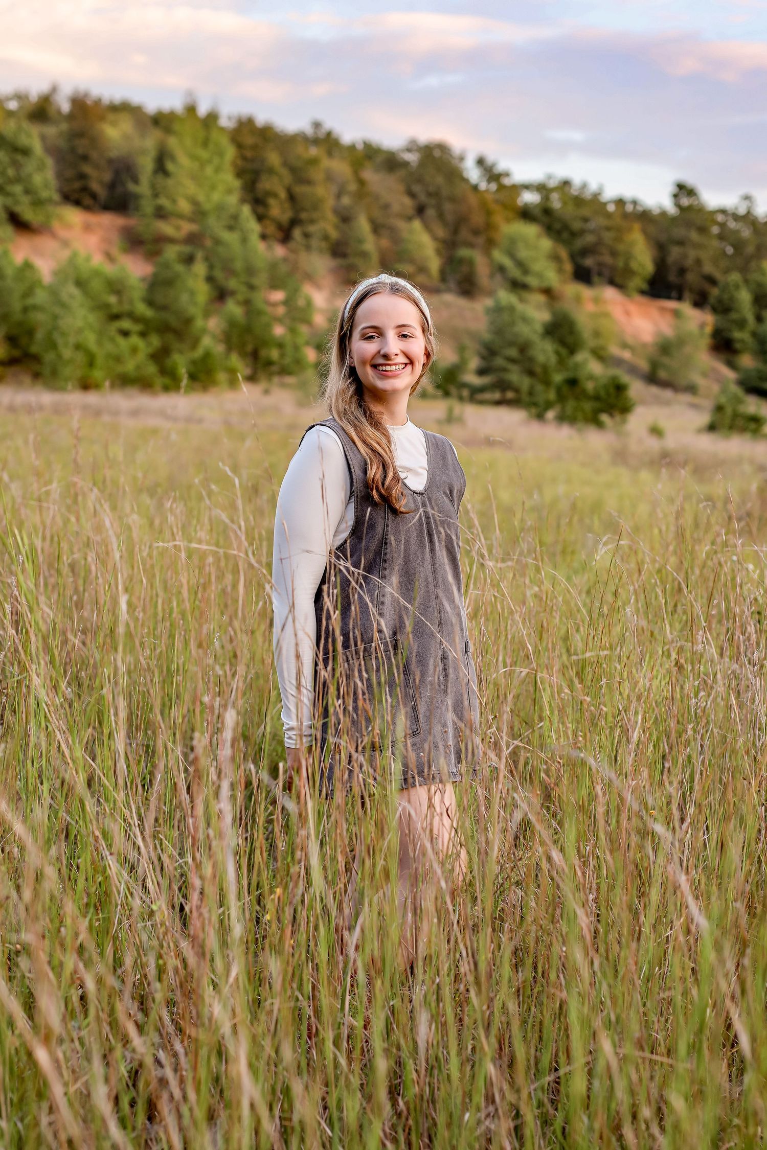Natural portrait session in tall grass field during golden hour.