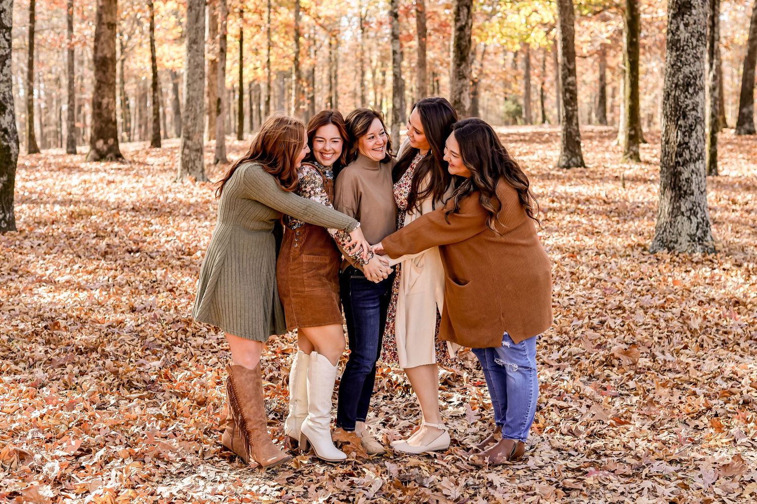 Group of friends huddling together in autumn forest setting.