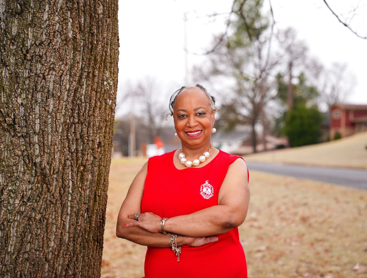 Outdoor professional portraits in red attire against natural backdrop with trees.