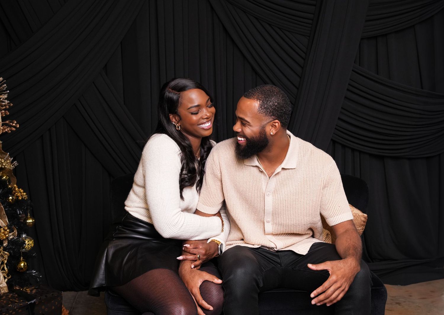 Intimate couple photoshoot against a dark backdrop with romantic lighting and poses.