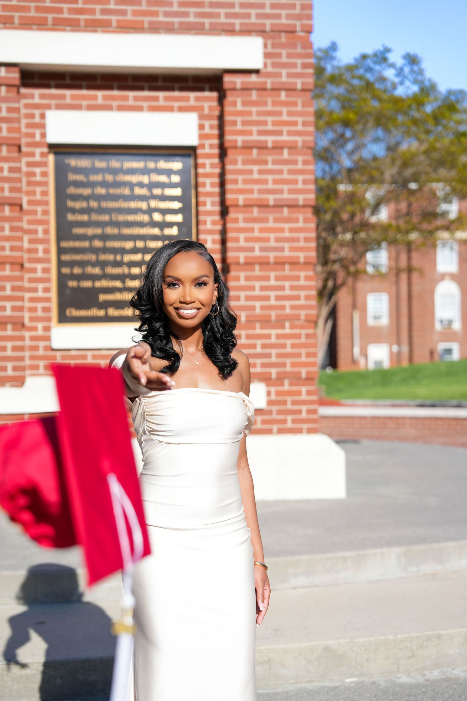 Outdoor portraits in white formal dress against brick building backdrop.