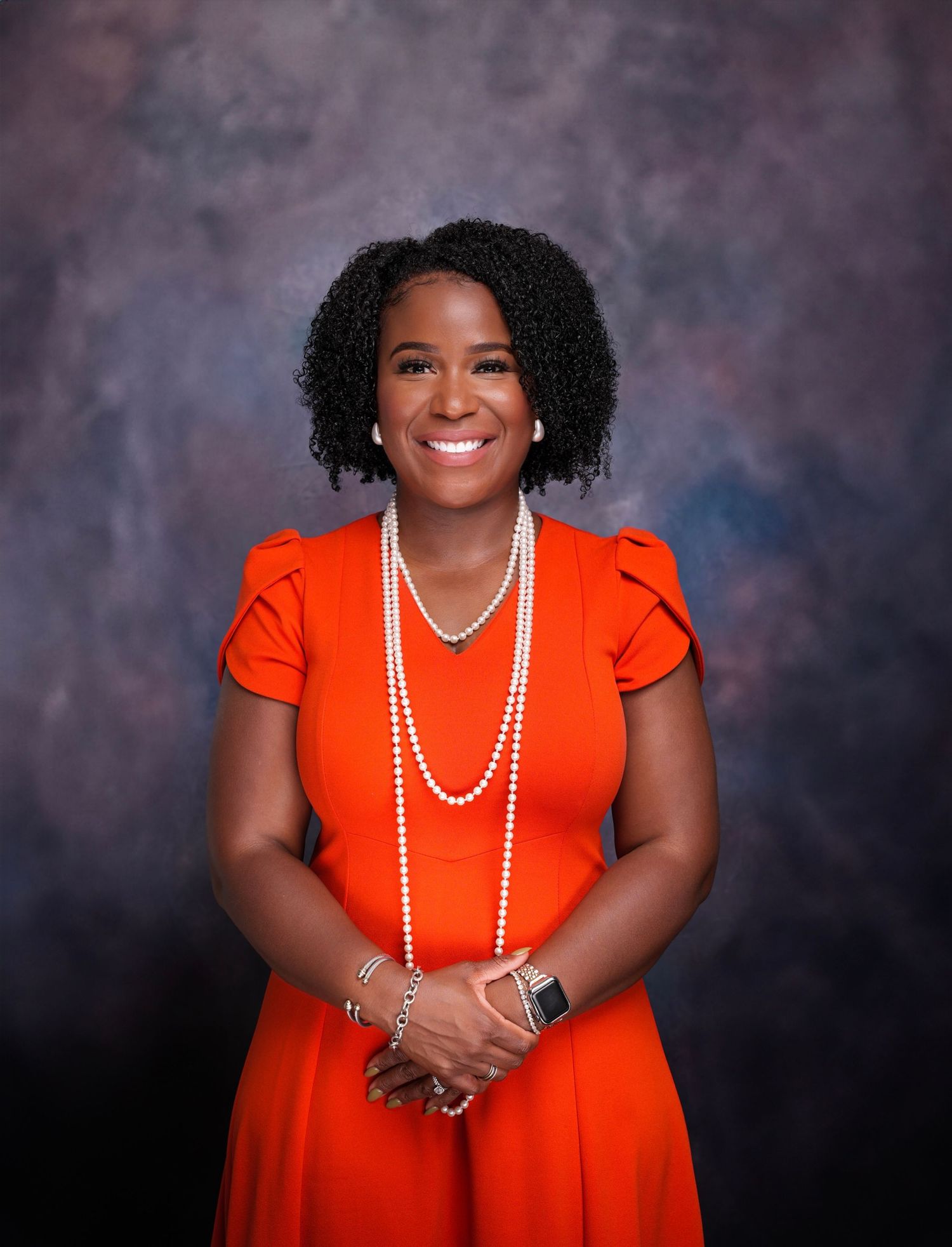 Professional portrait series in vibrant red dress with pearl necklace.
