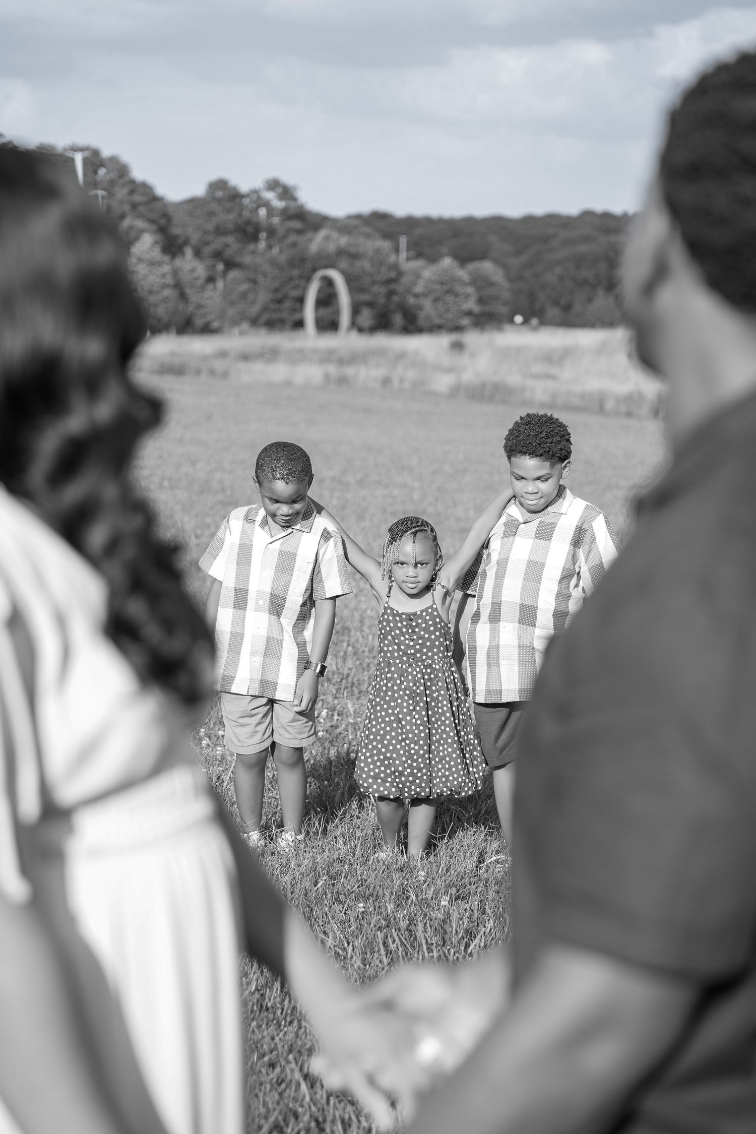 A group of people walking together in a grassy field wearing striped outfits.