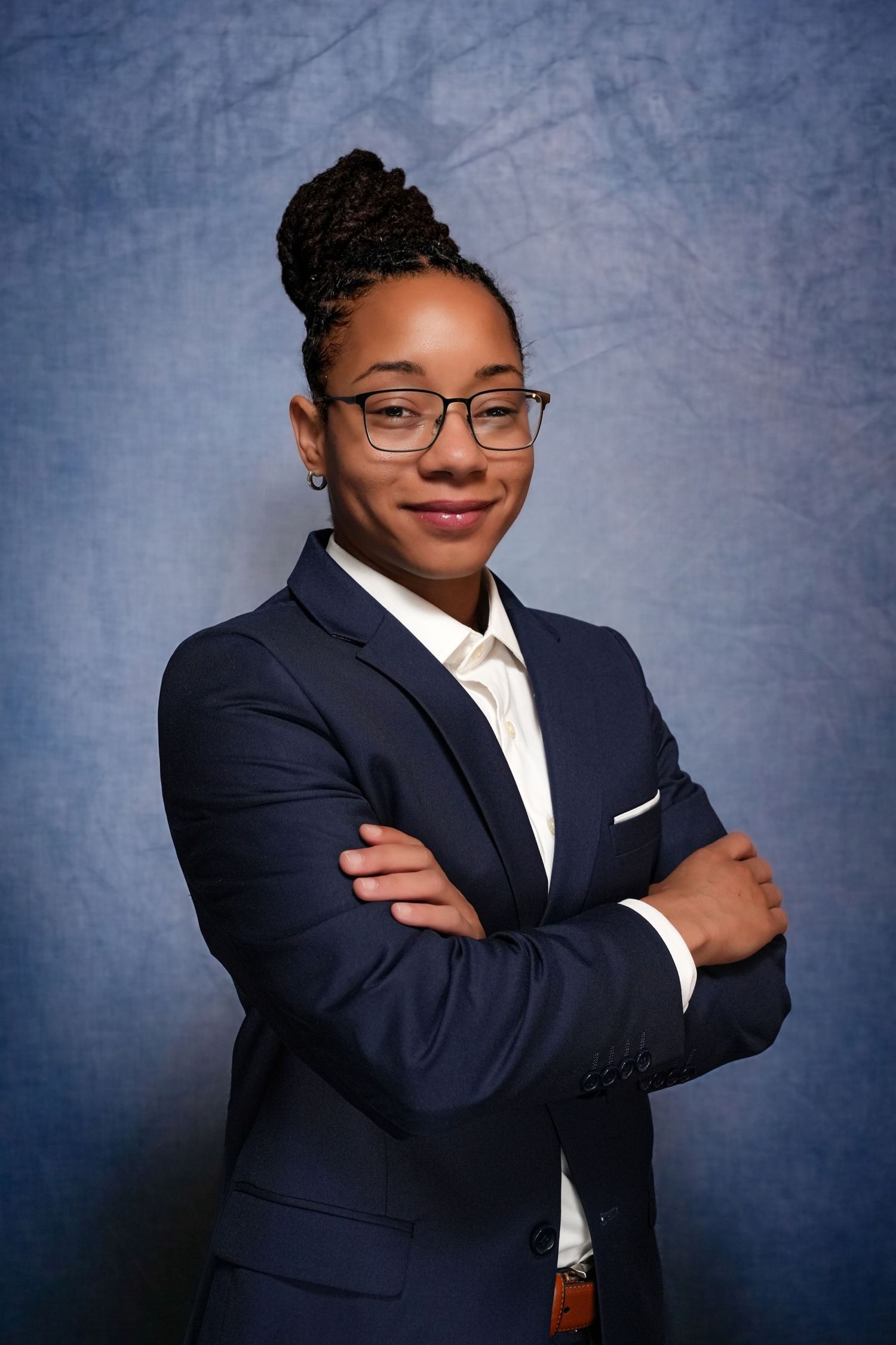 Portrait series showing professional poses in dark blazer against textured background.