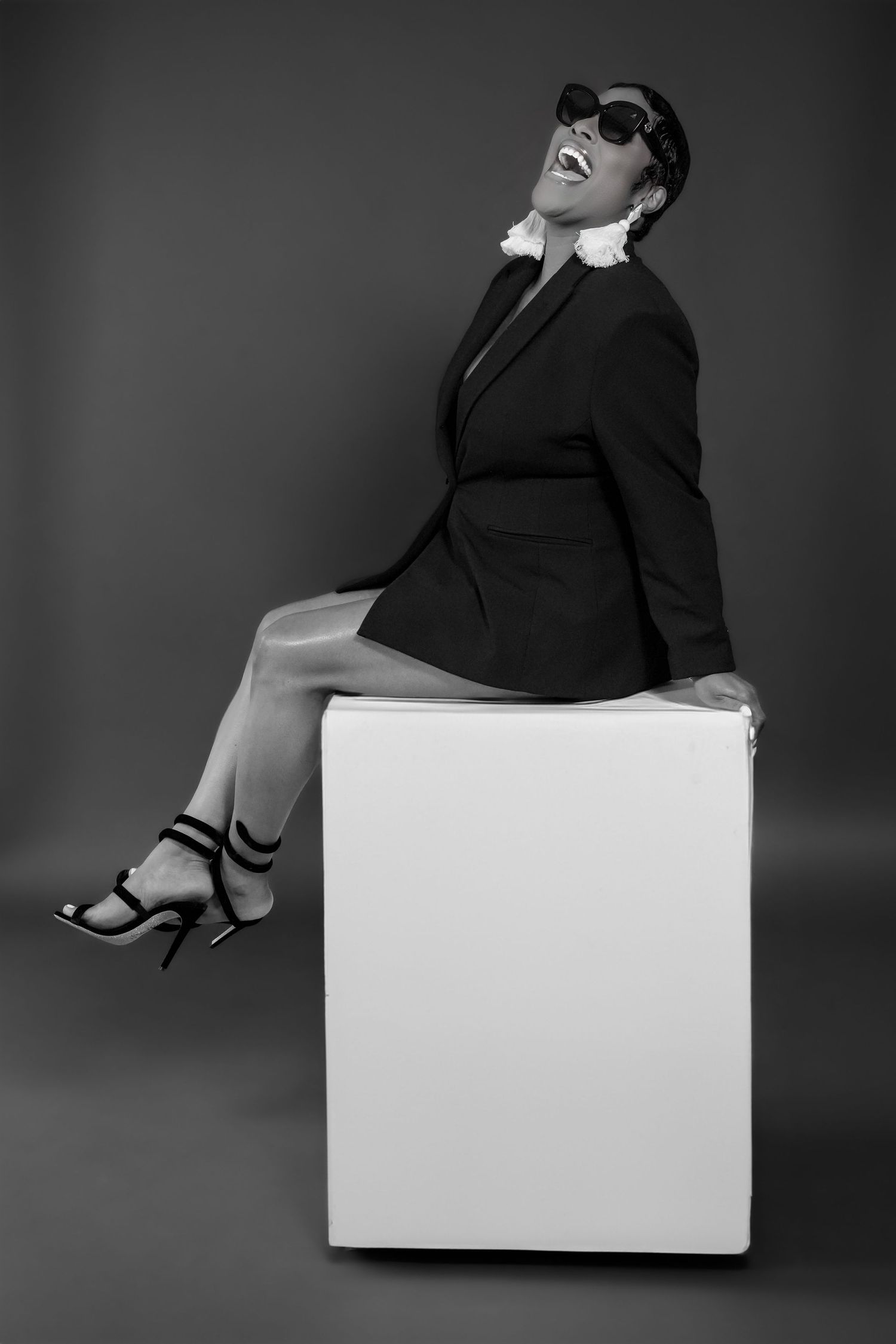 Dramatic black and white fashion portraits on a white cube with sleek styling.