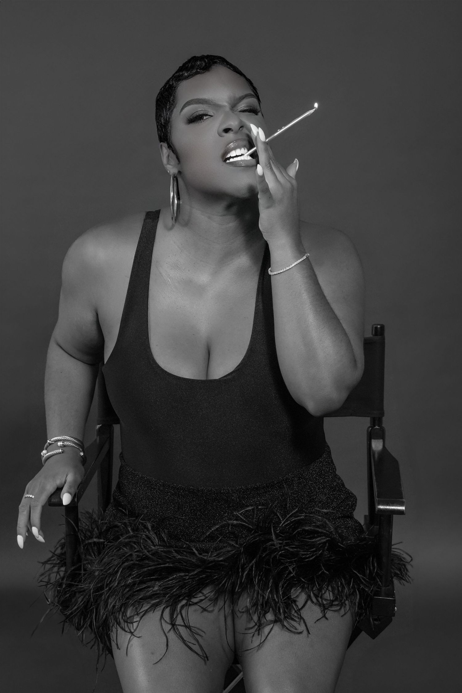 Dramatic black and white portraits featuring person in black top with feather trim.