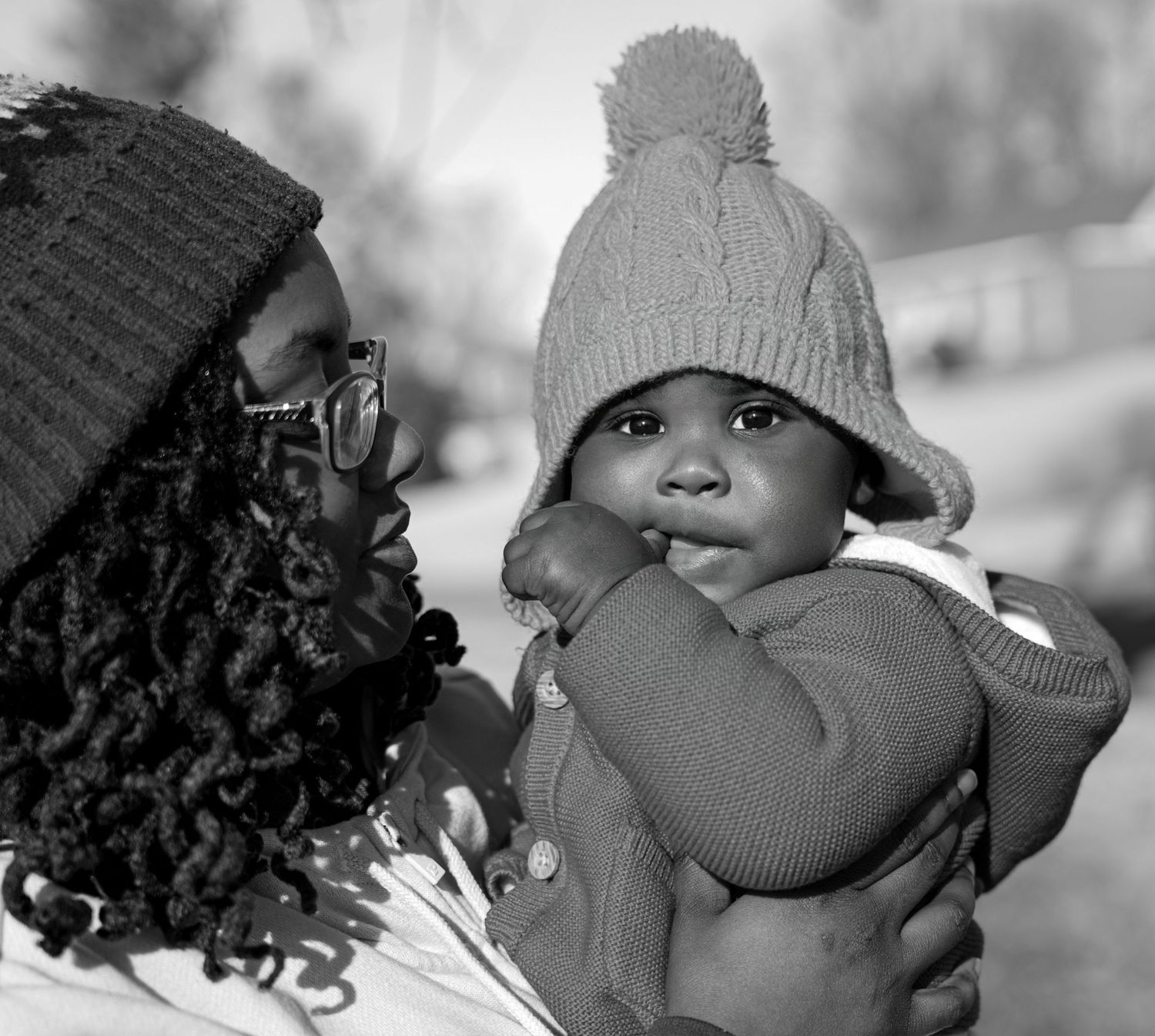 Series of black and white winter portraits showing cozy knit hats and curly hair.
