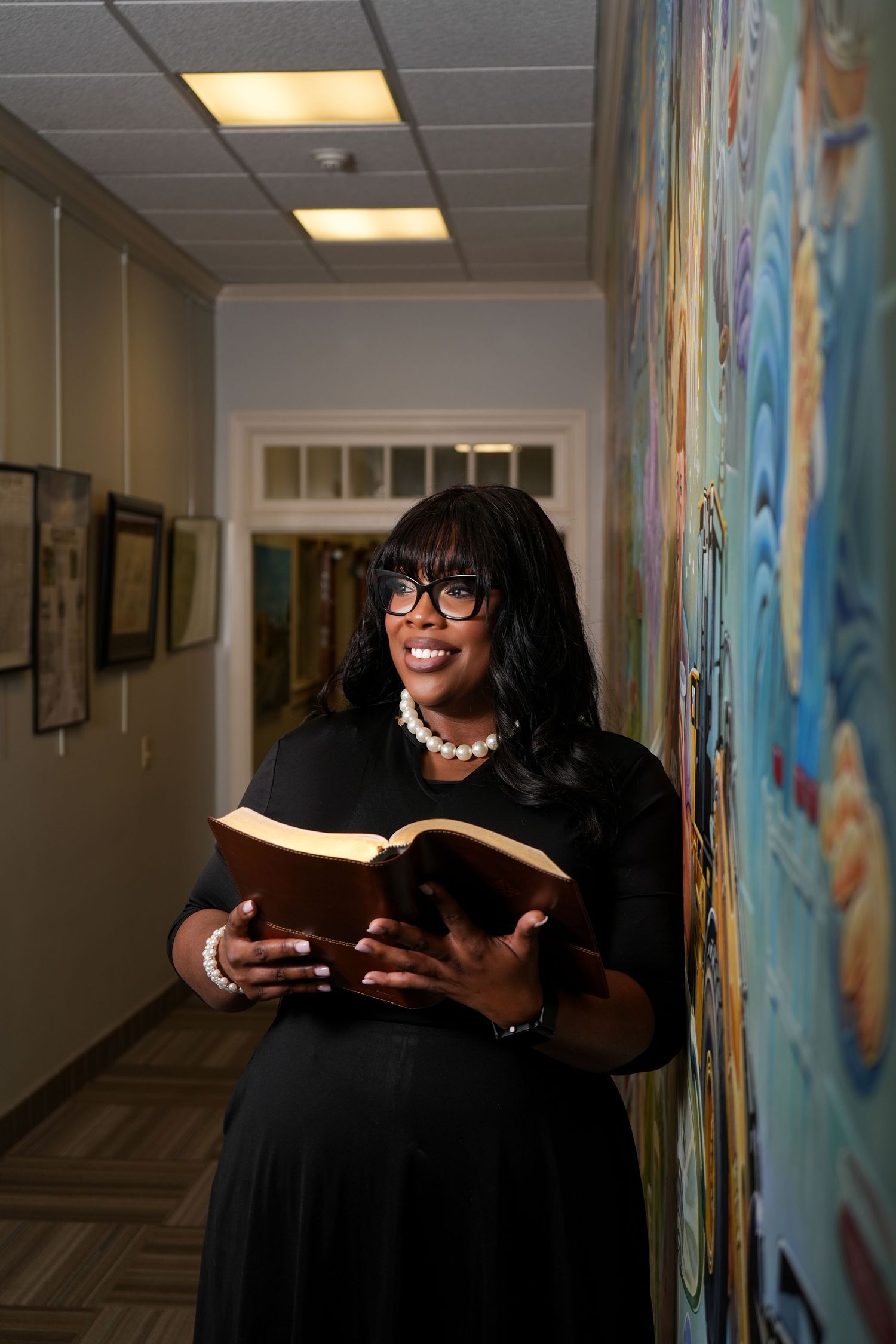 Series of photos showing someone reading a book in a hallway with a colorful mural.